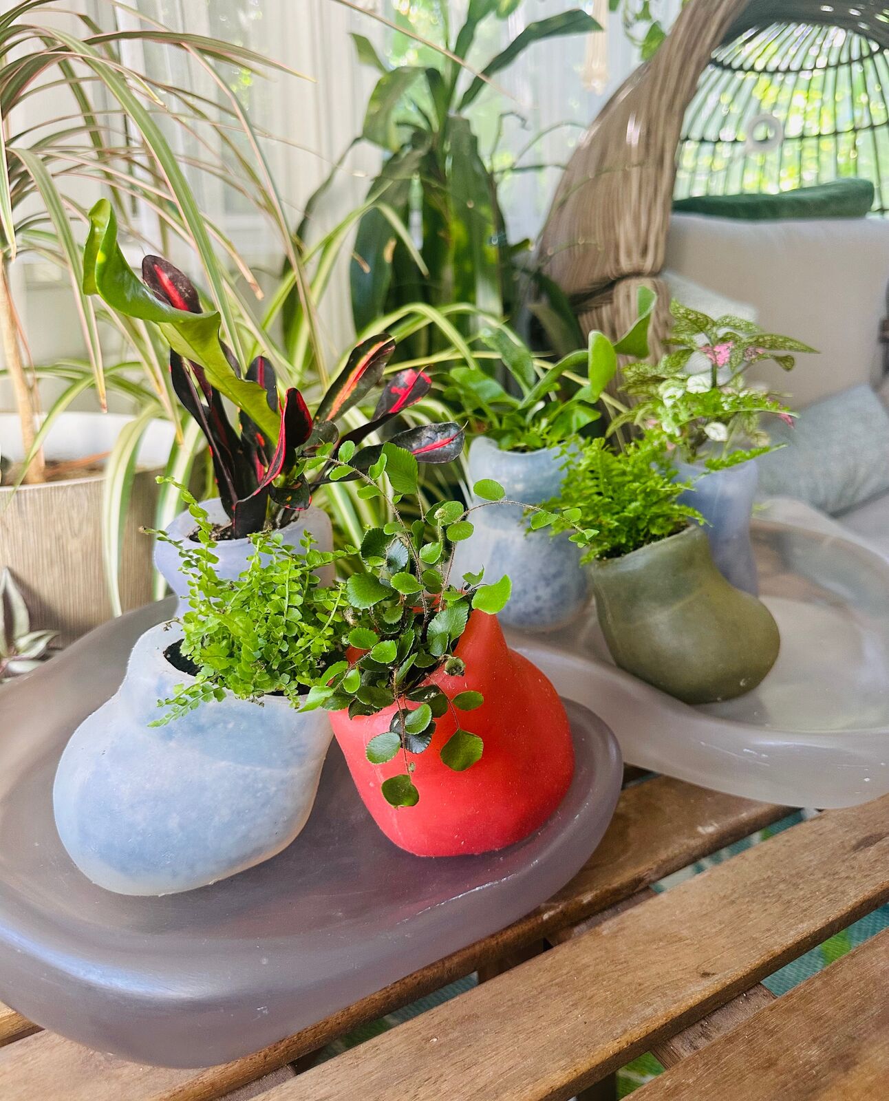 Artwork by Paula Hayes, Six mini silicone planters and two trays, Made of Planters: Cast silicone, Trays: Cast resin 