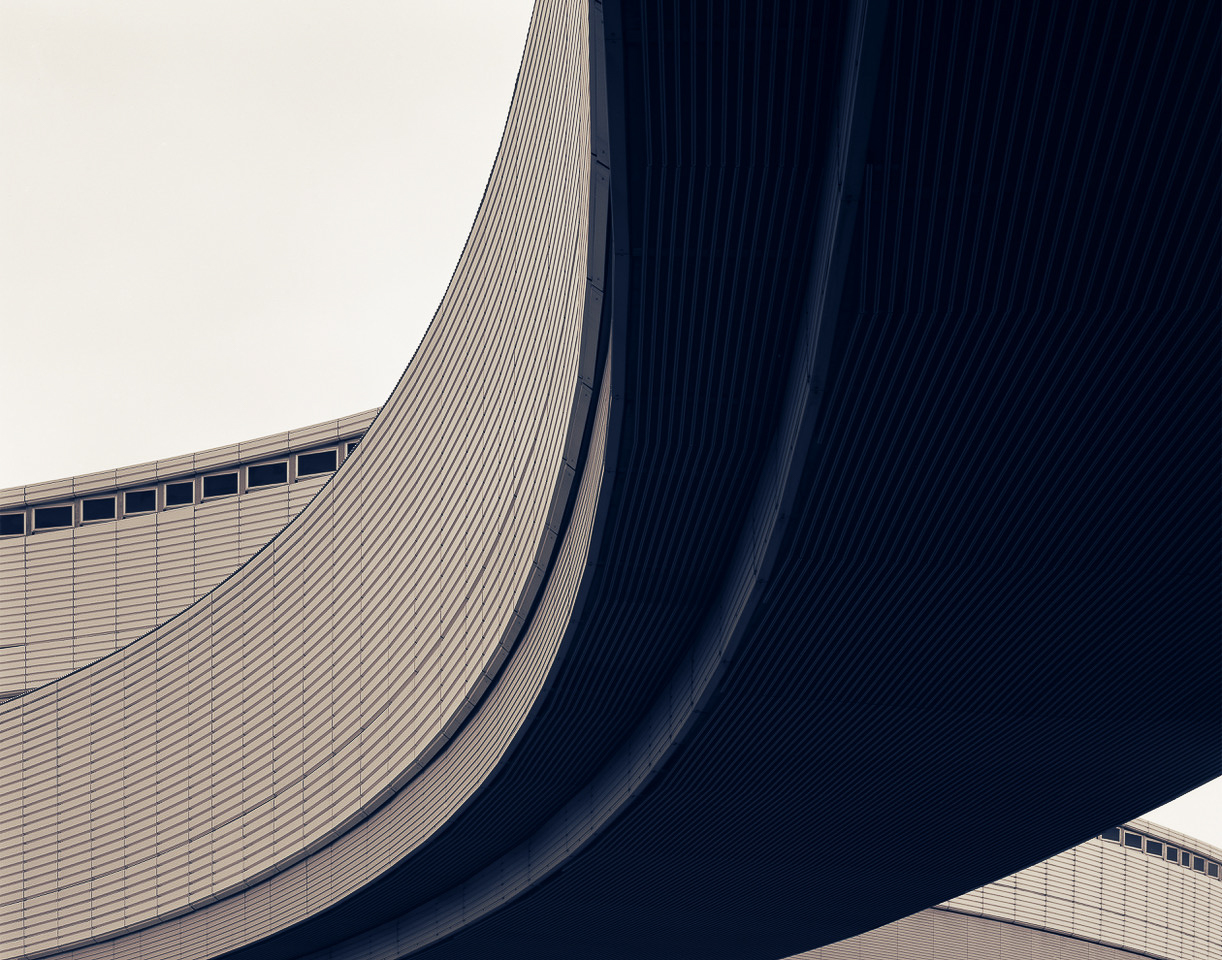 A black and white photo of a curved building.