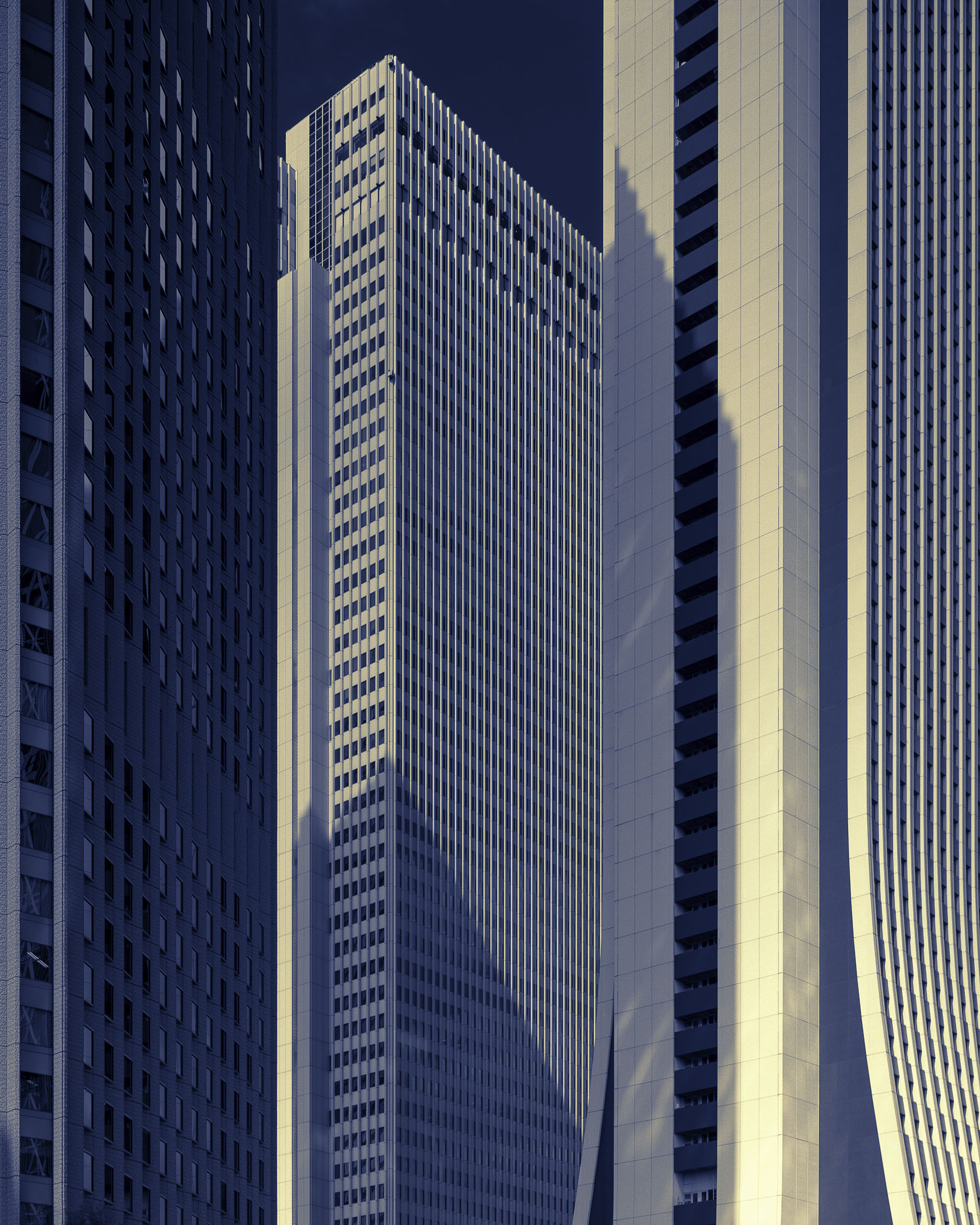 A group of tall buildings in a city at night.