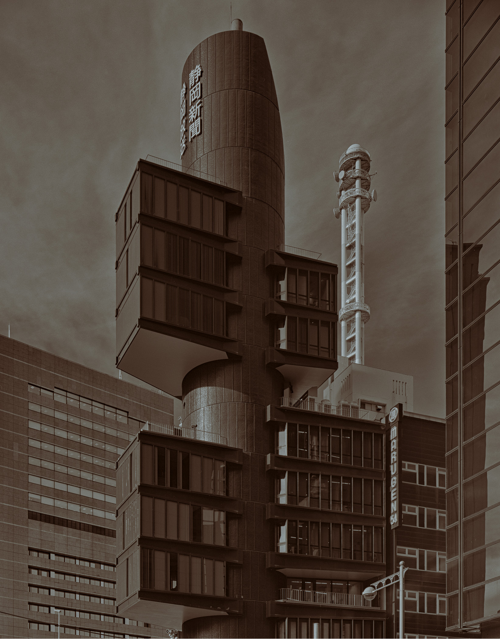 A tall building with a tall tower in the background.