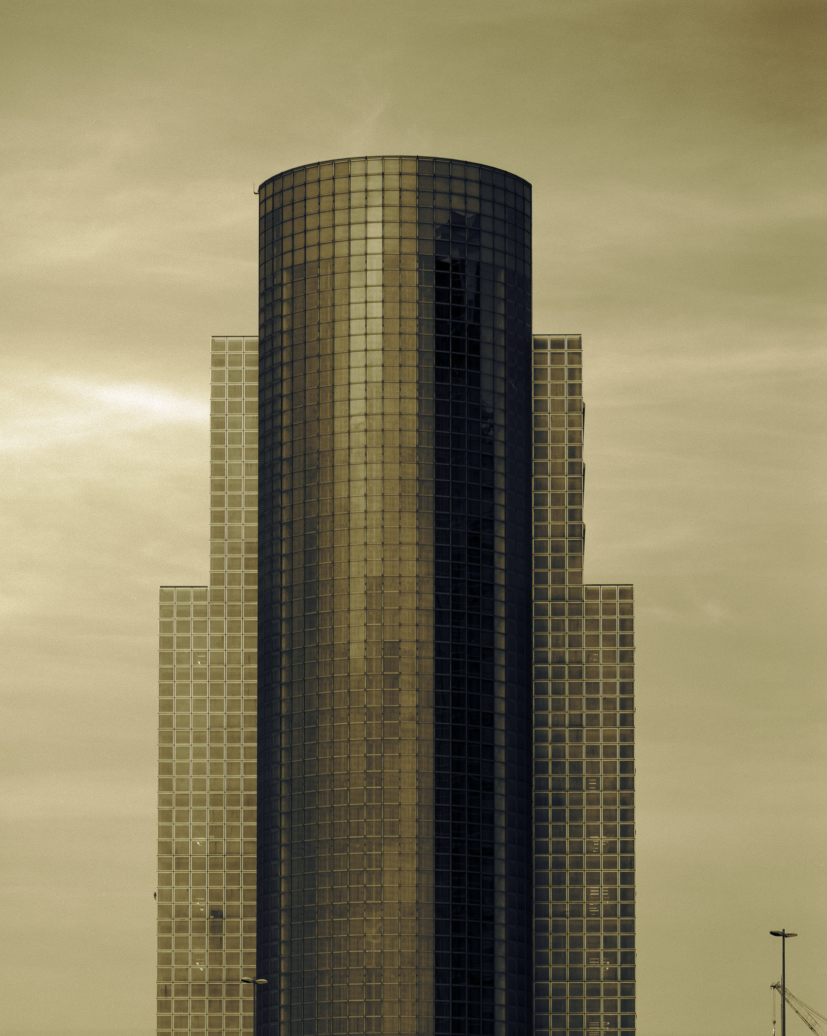 A tall building with many windows in the middle of a city.