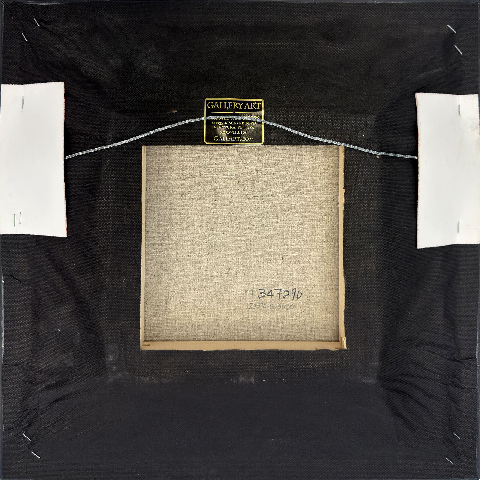 A painting of colorful flowers in a vase in a gold frame.