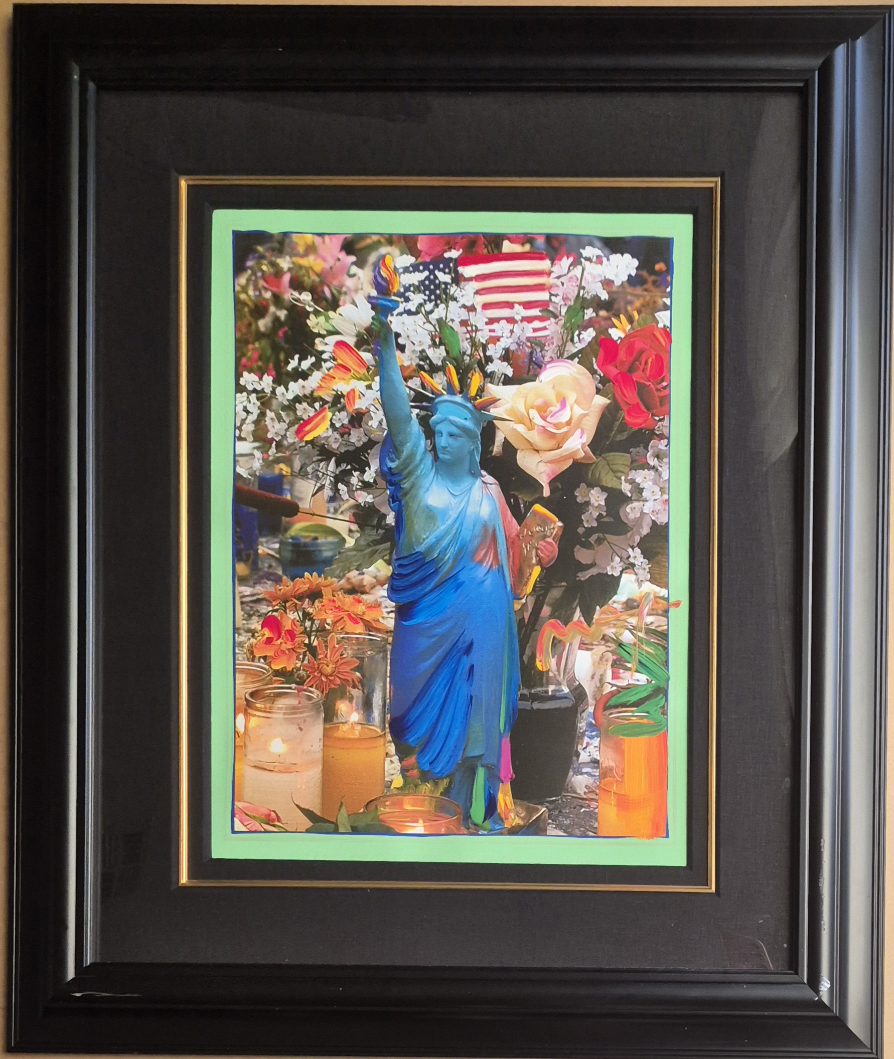A statue of liberty surrounded by flowers and candles.