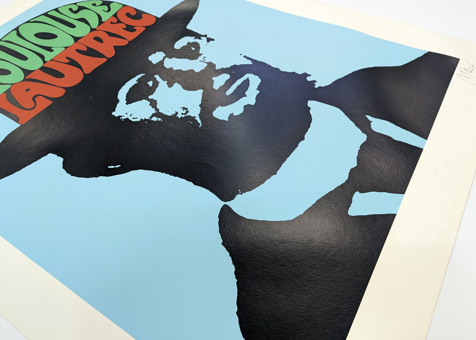 A bold graphic portrait of a bearded figure in silhouette against a light blue background, wearing a hat filled with colorful text.