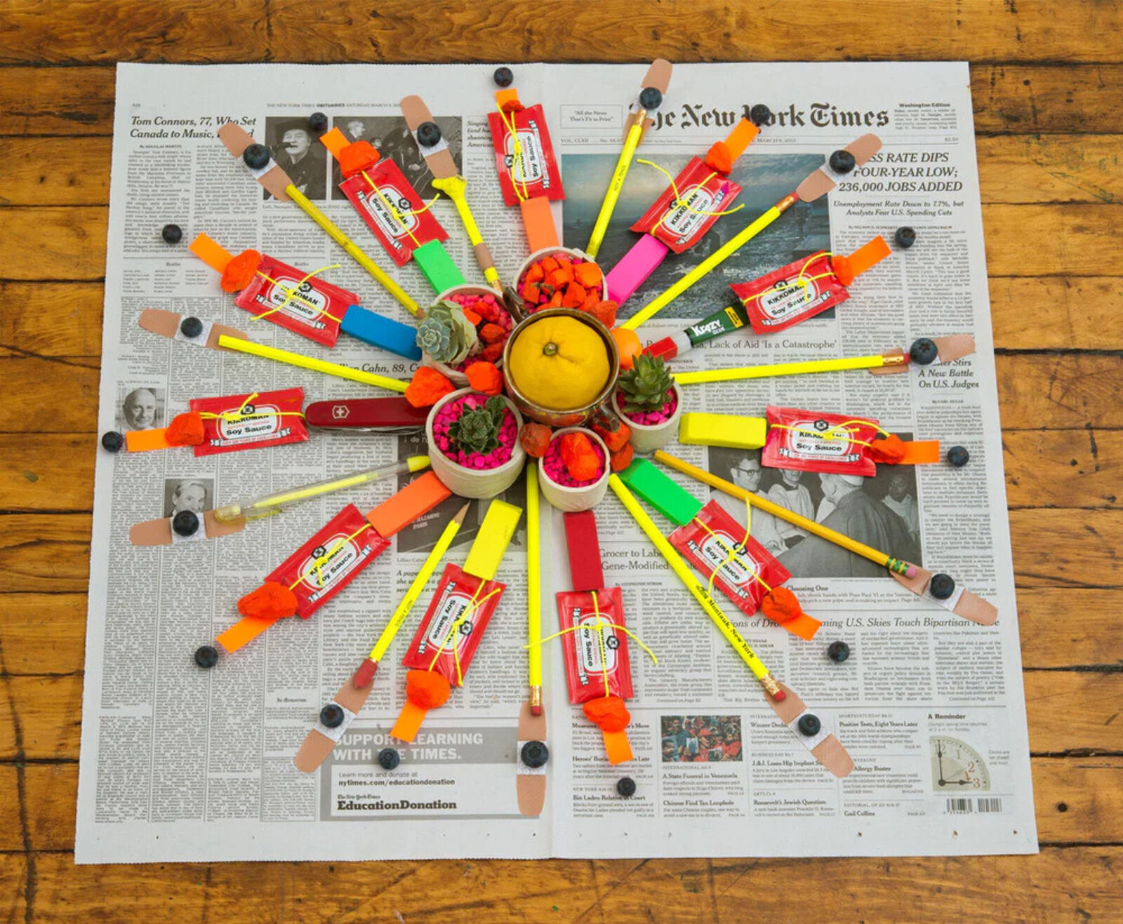 A newspaper with a bunch of pencils on top of it.
