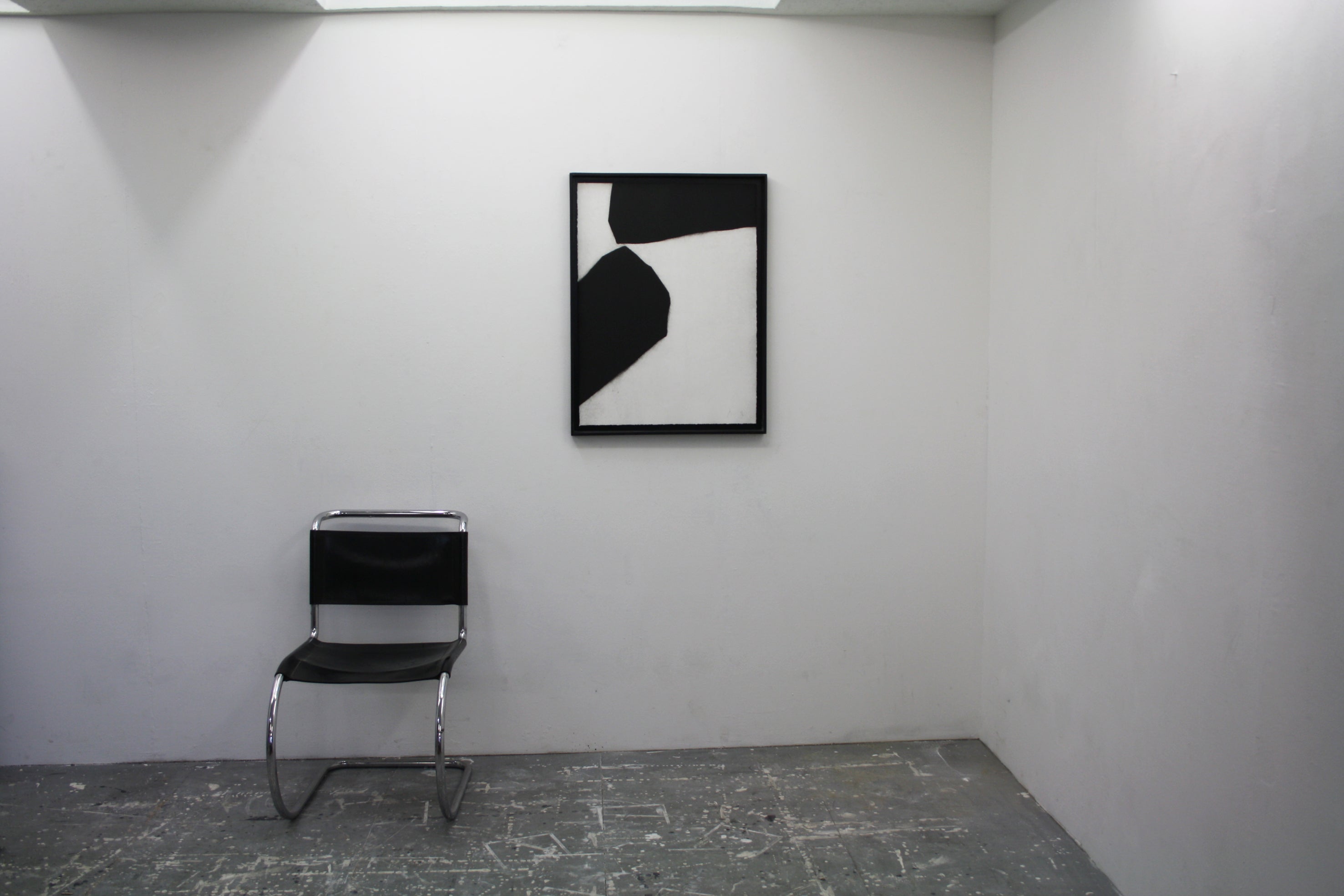 A black and white painting on a white wall.