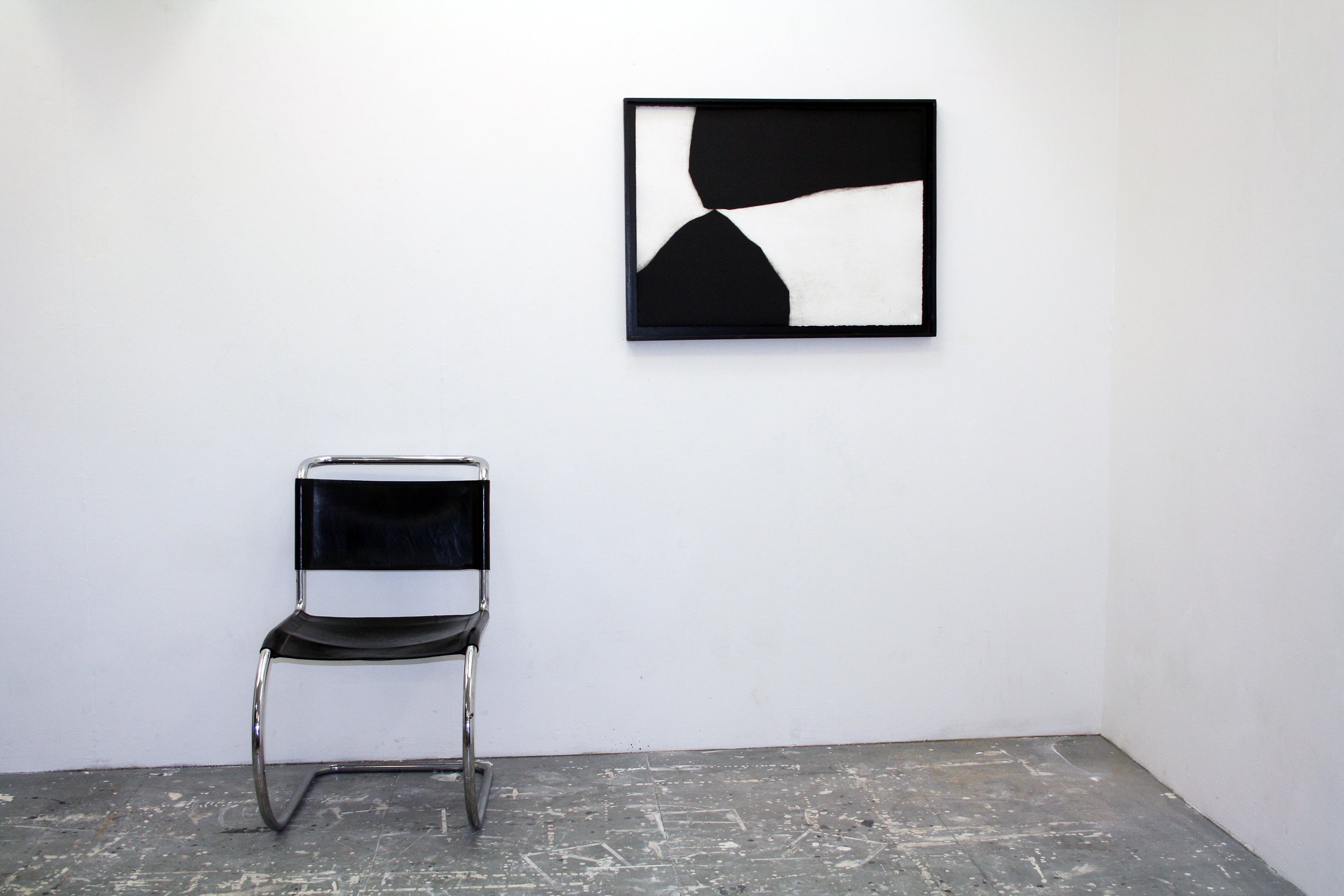 A black and white painting on a white wall.
