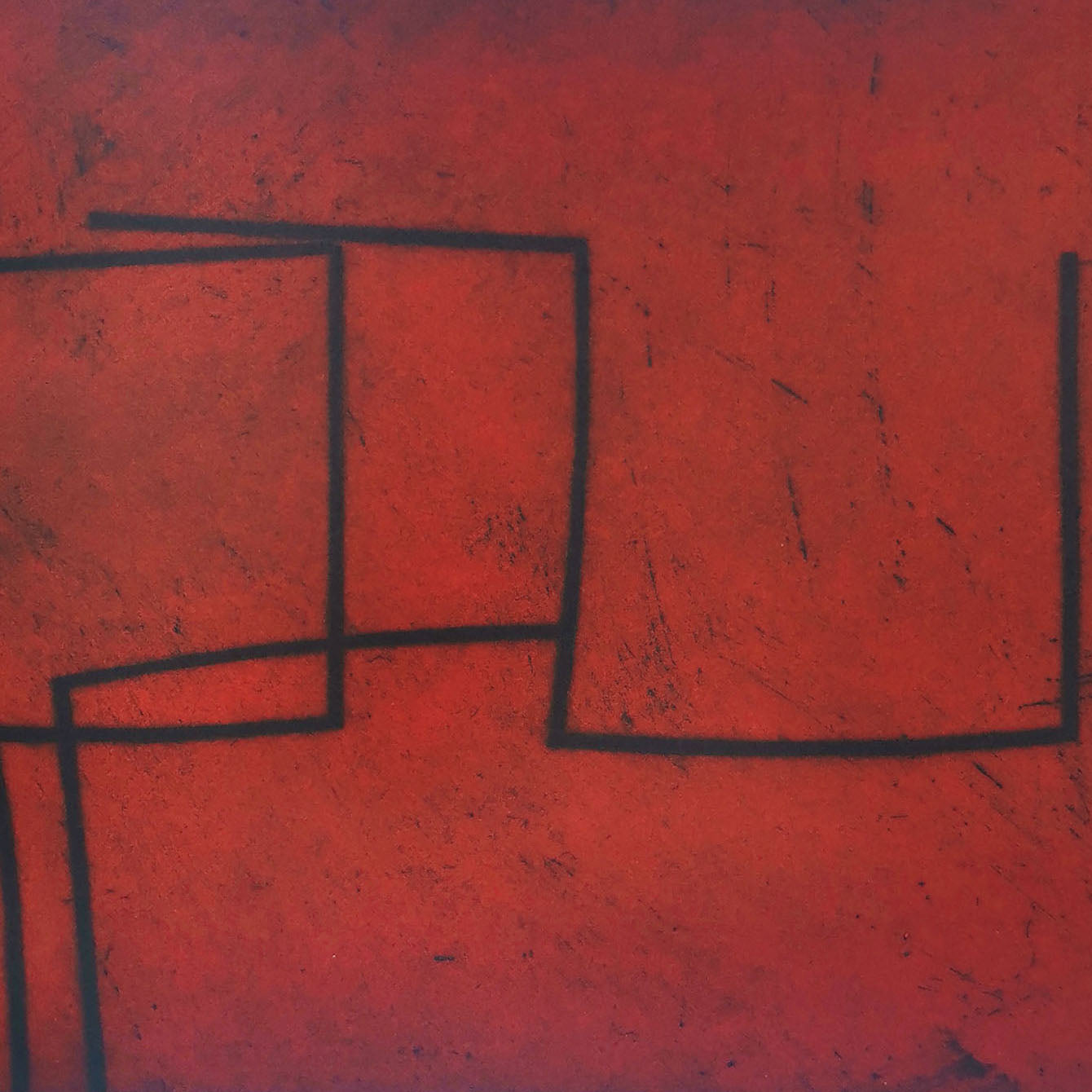 A red and black painting on a white wall.