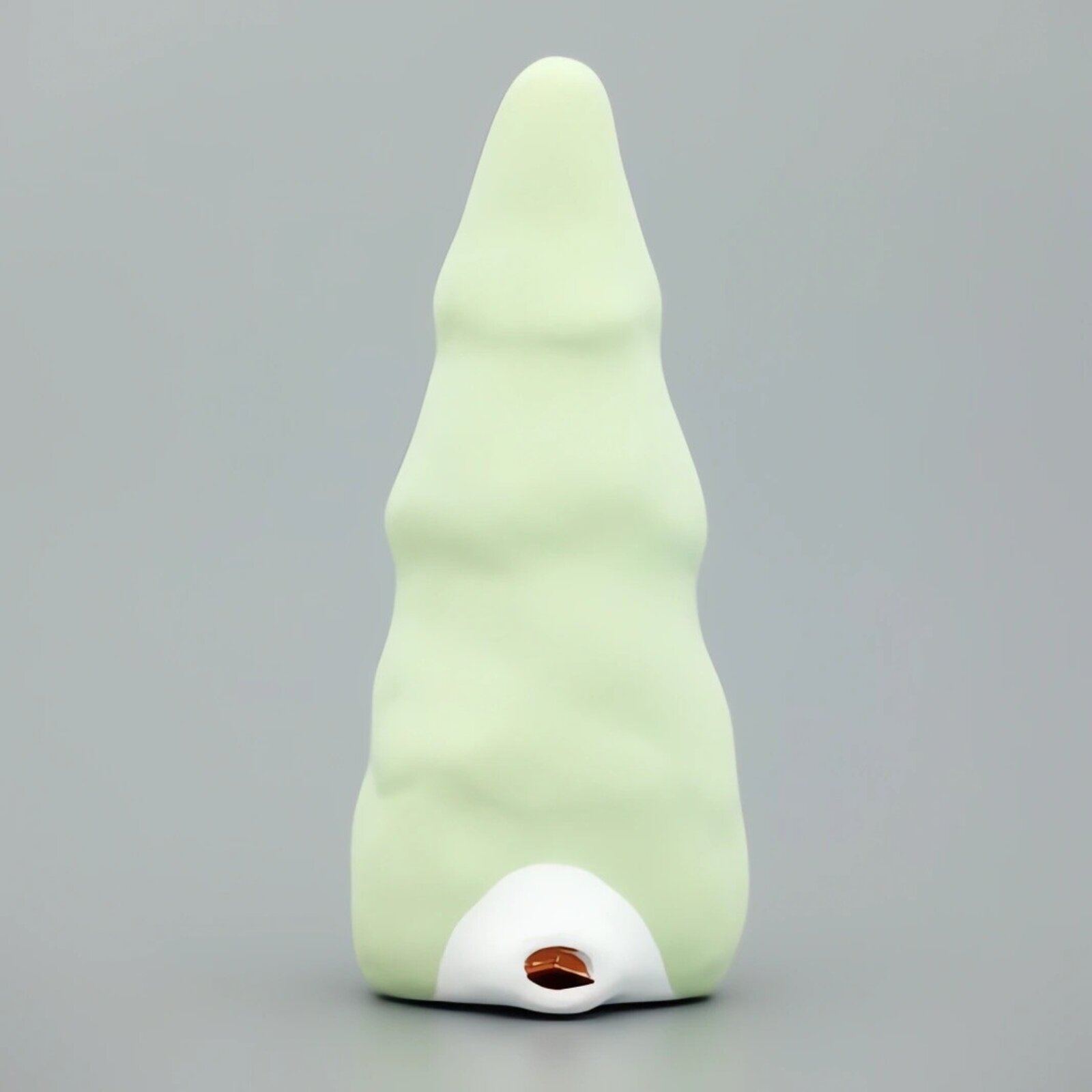 A whimsical ceramic figure with a tall, pointed green head and a serene white face.