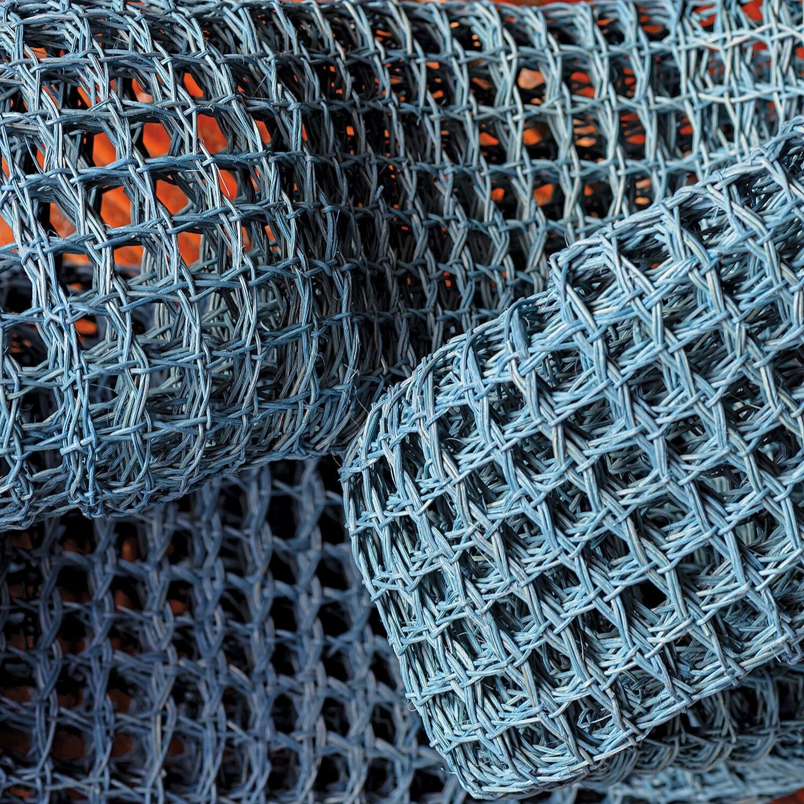 A blue mesh sculpture shaped like a figure-eight resting on a reflective surface.