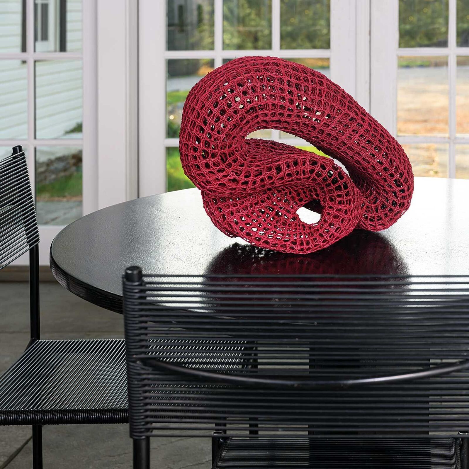 A black table with a red sculpture on top of it.