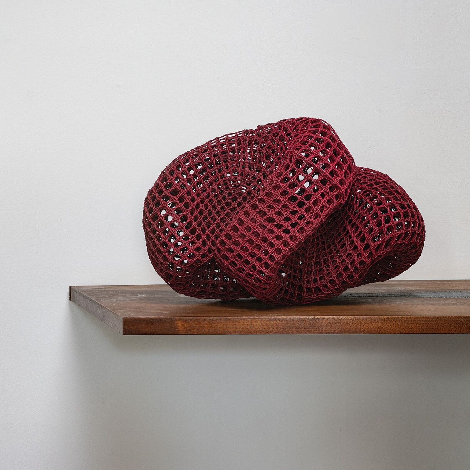 A black table with a red sculpture on top of it.