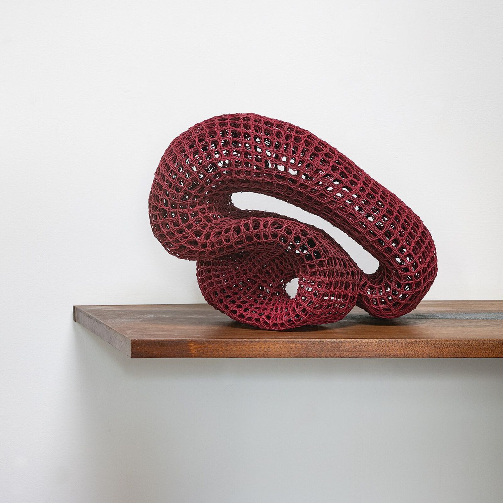 A black table with a red sculpture on top of it.