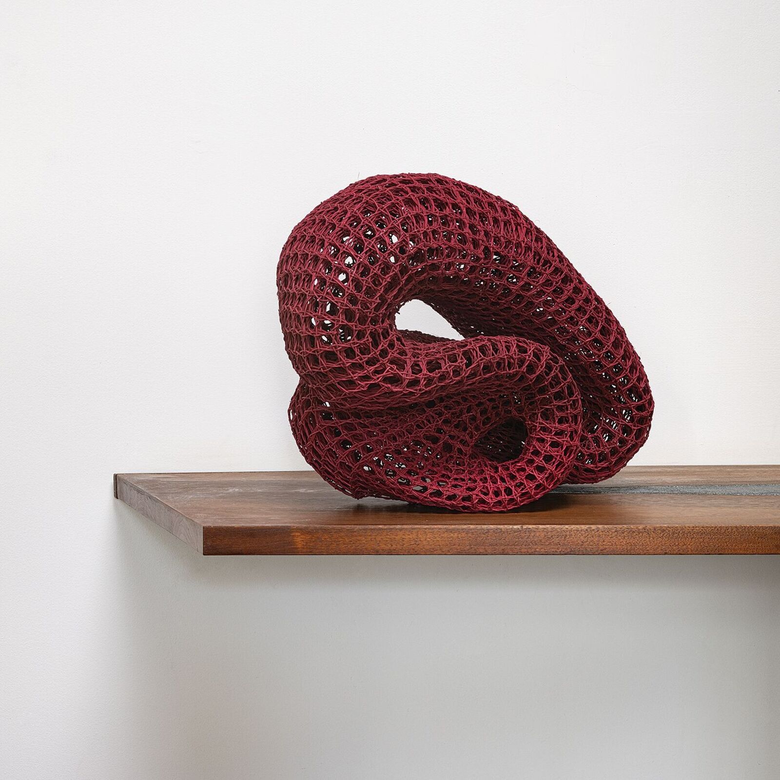 A black table with a red sculpture on top of it.