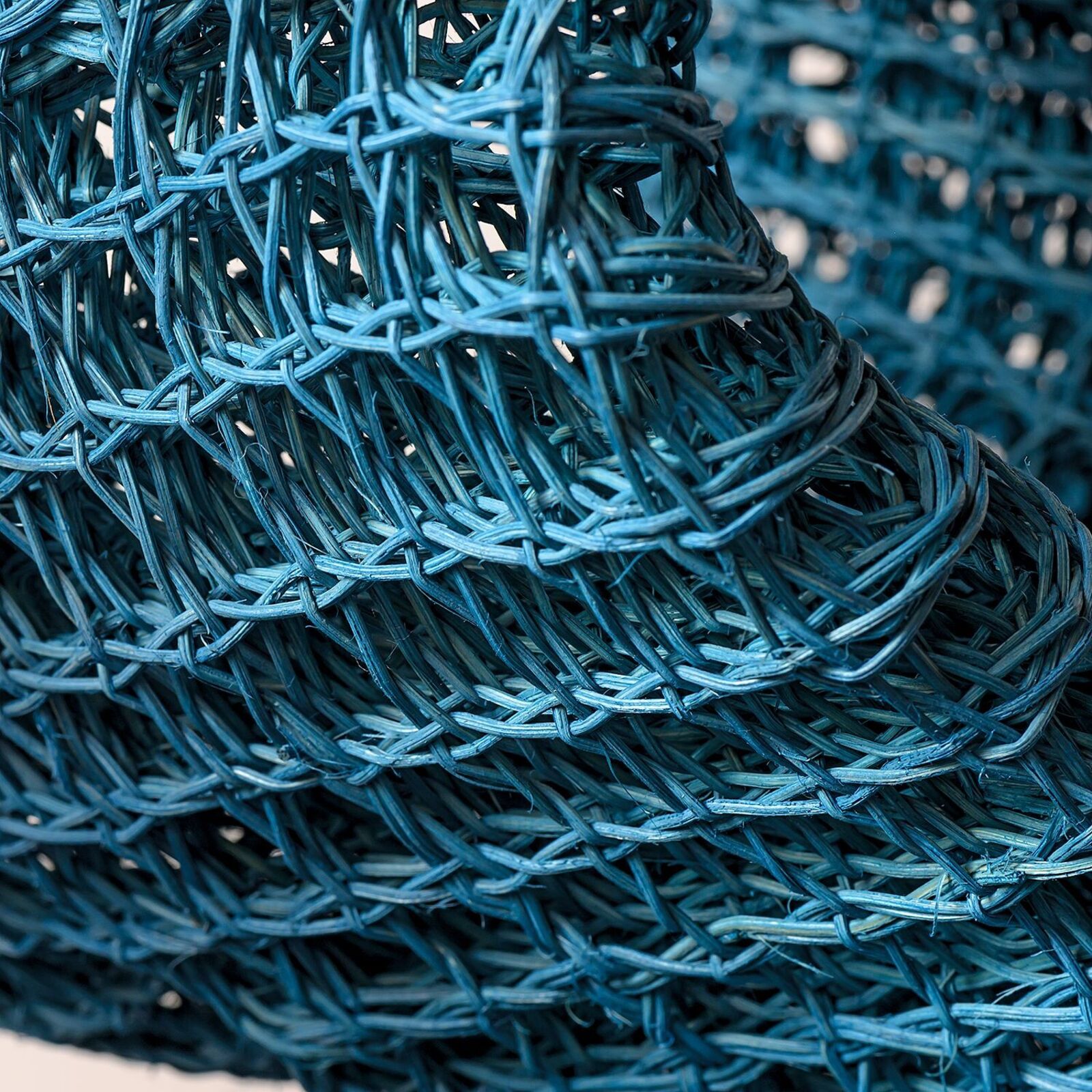 A blue sculpture on a wooden table on a hardwood floor.