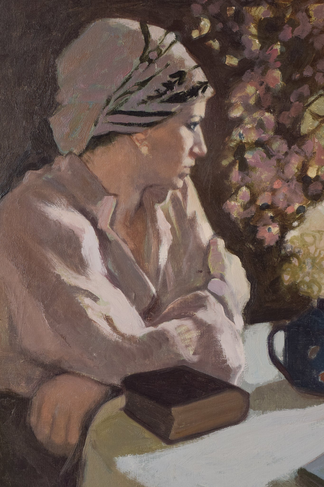 A painting of a woman sitting at a table with a book and a vase of flowers.