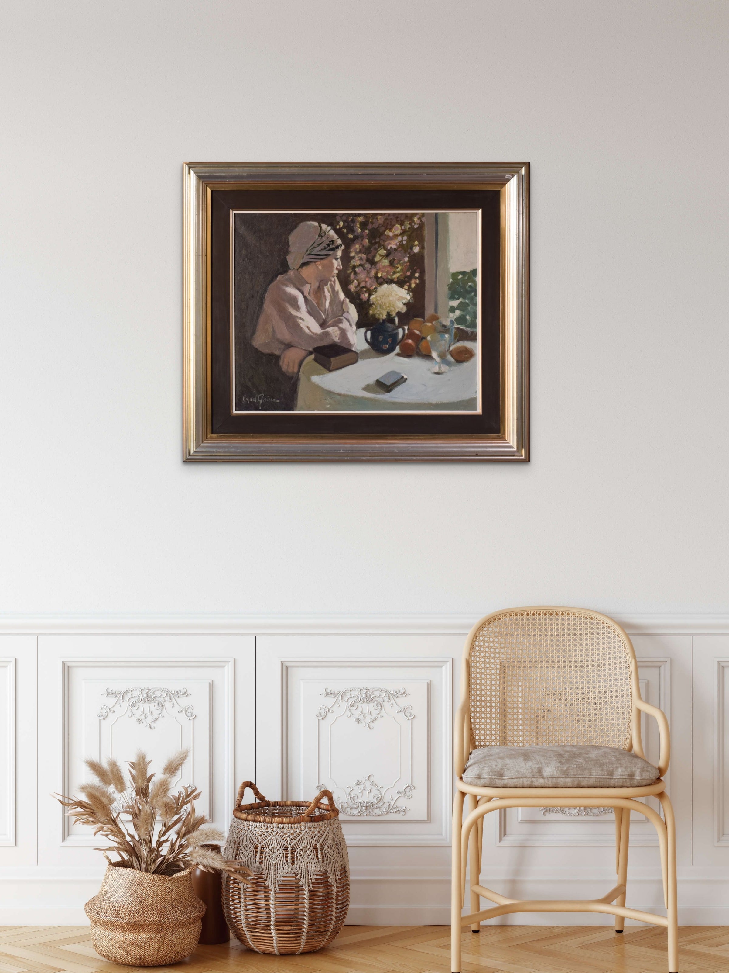 A painting of a woman sitting at a table with a book and a vase of flowers.