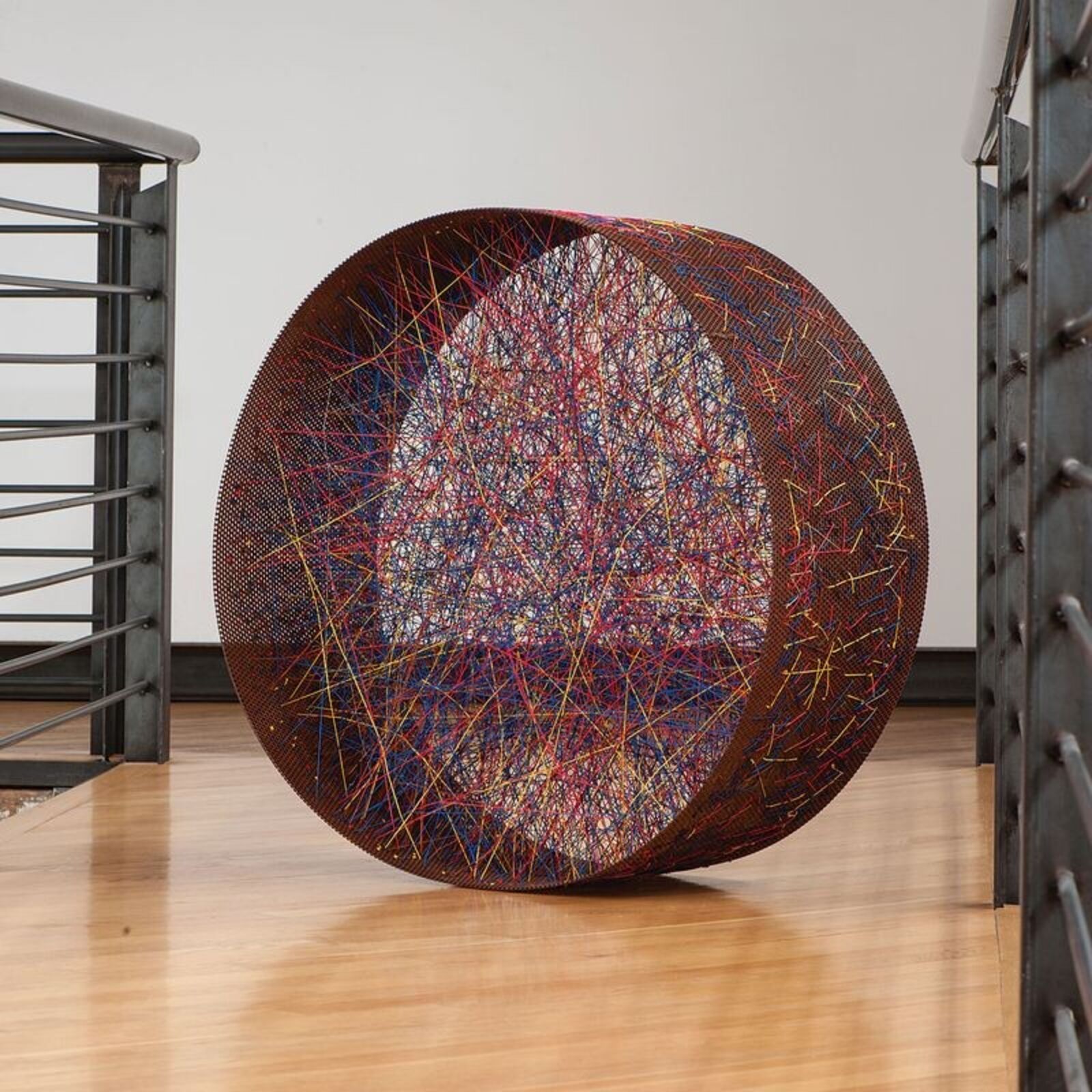 A large metal sculpture on a wooden floor in a room.