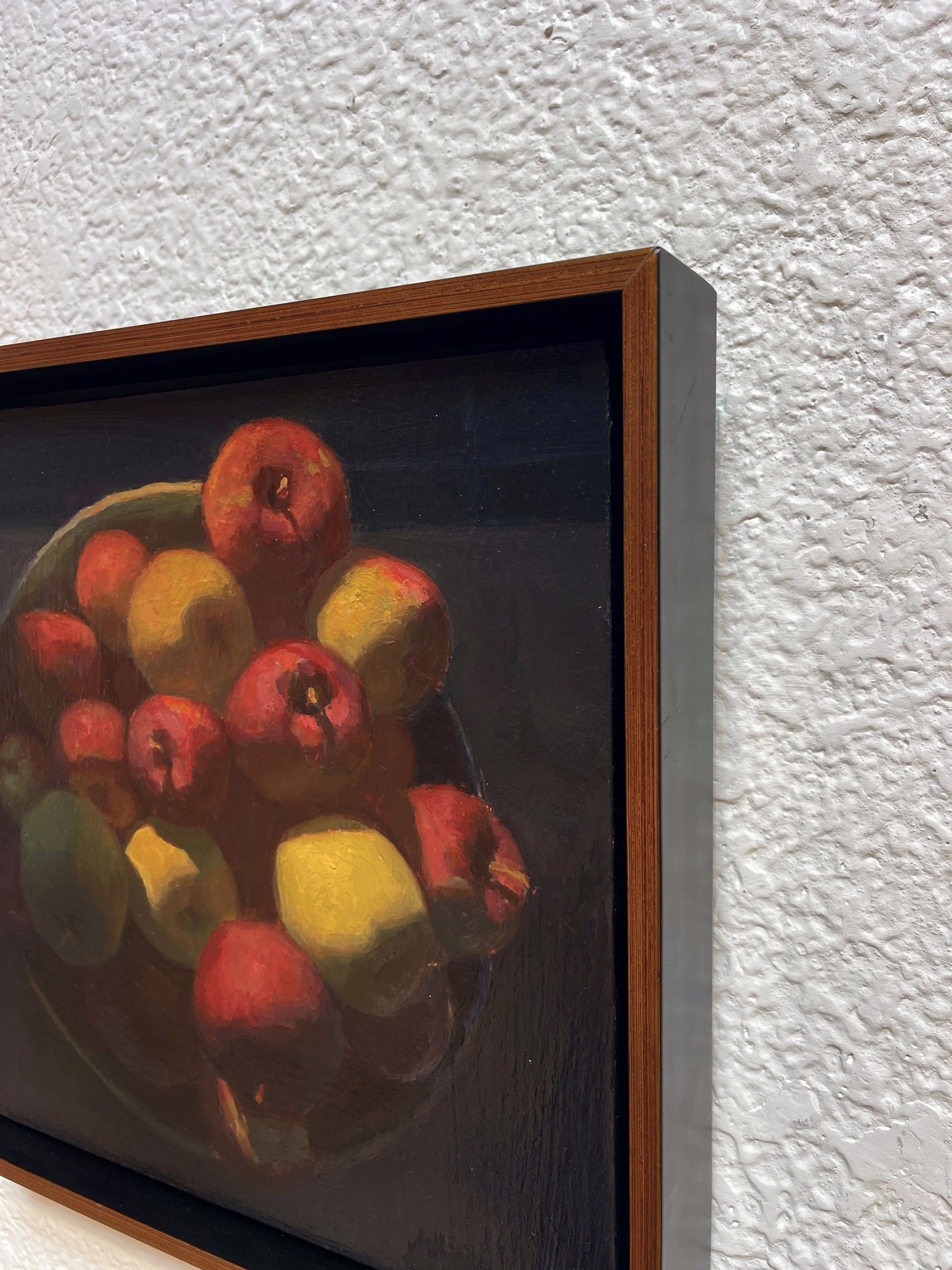 A painting of apples and lemons in a bowl on a table.