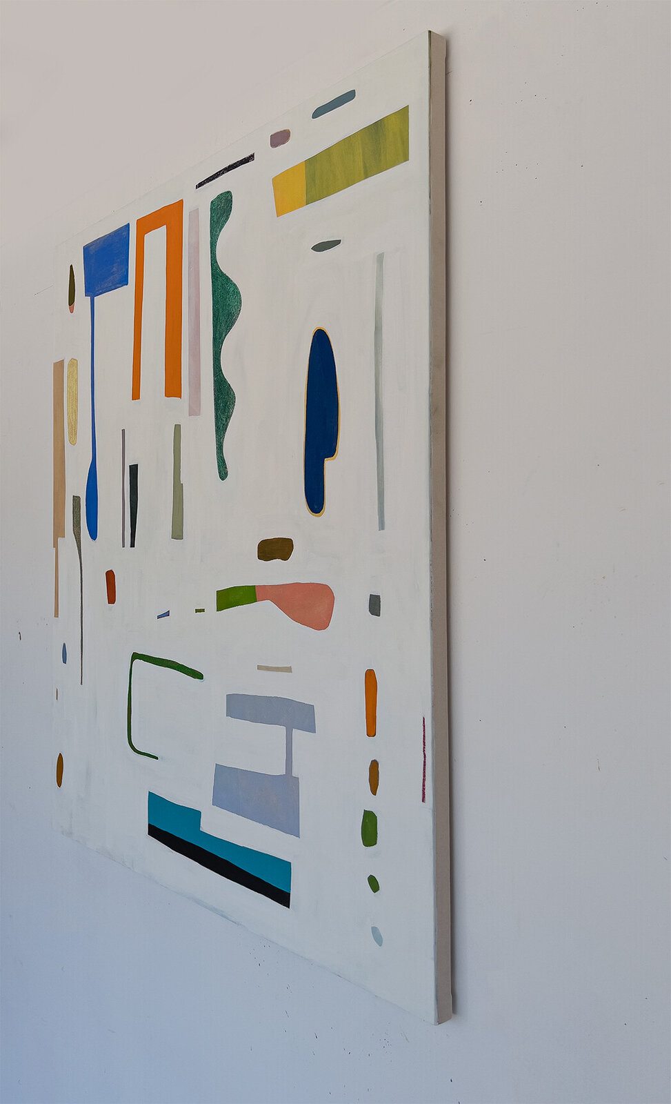 An abstract composition featuring a scattered arrangement of colorful geometric shapes and organic forms on a white background.