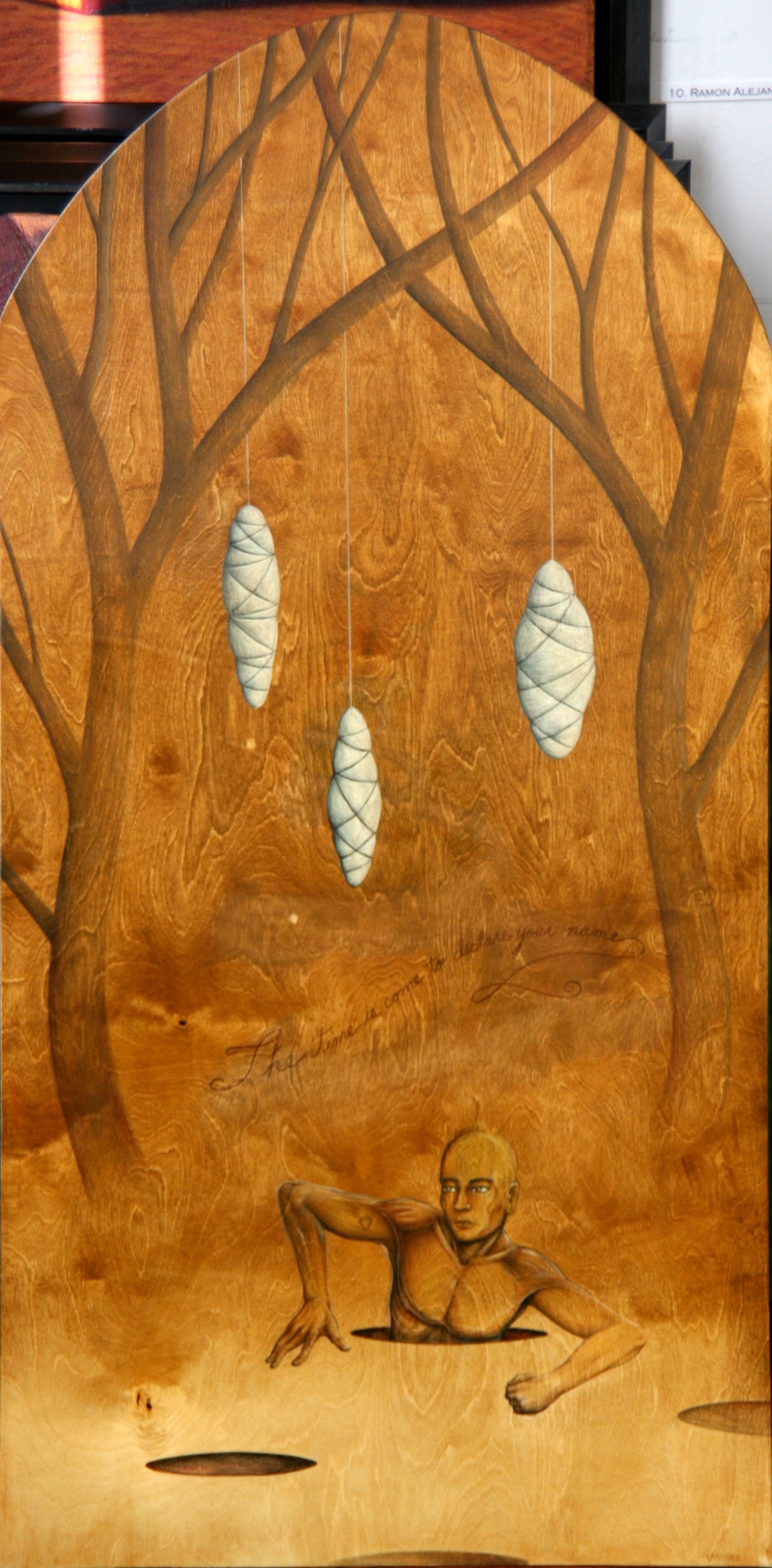 A wooden plaque with a drawing of a man in the woods.
