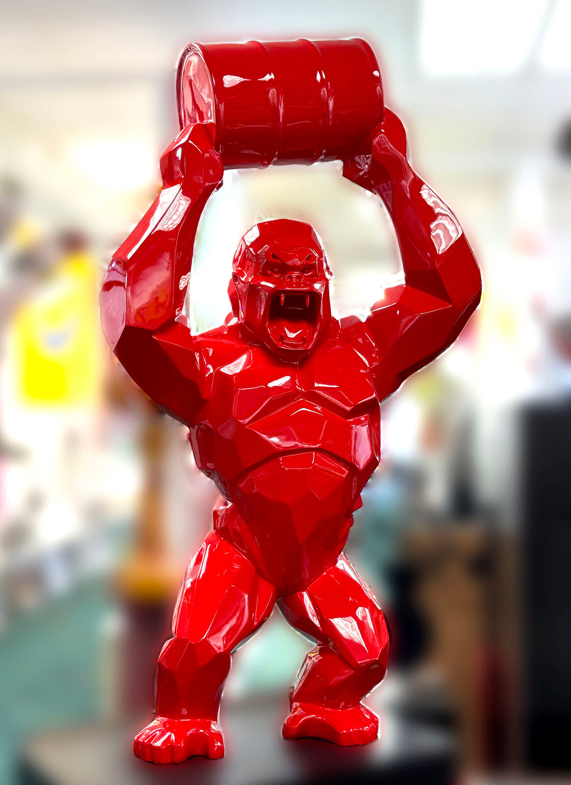 A glossy red gorilla figure lifting a barrel overhead in a low-poly style.
