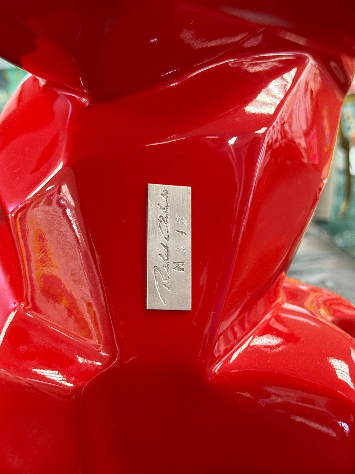A glossy red gorilla figure lifting a barrel overhead in a low-poly style.