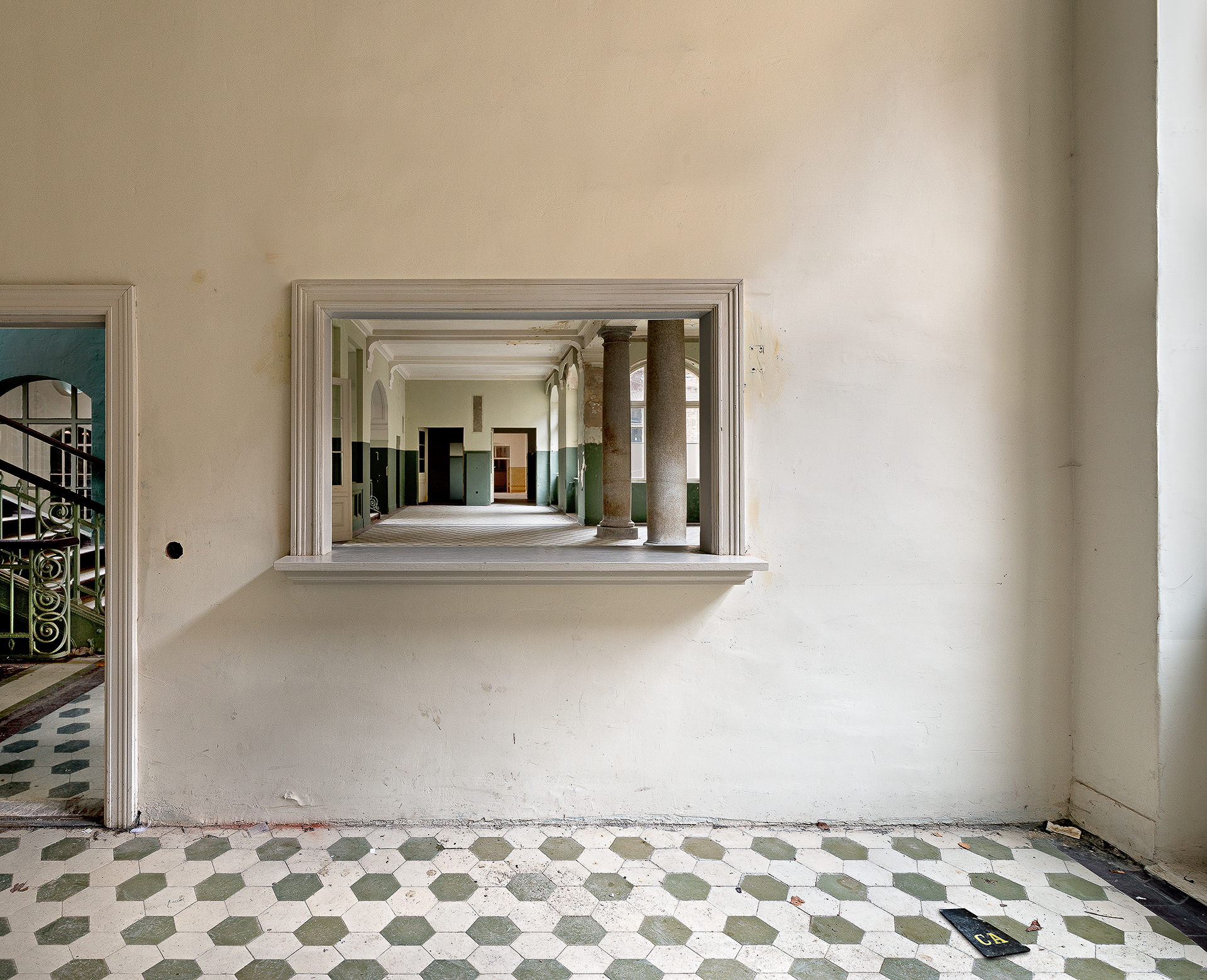 A view of a hallway through a window in an abandoned building.