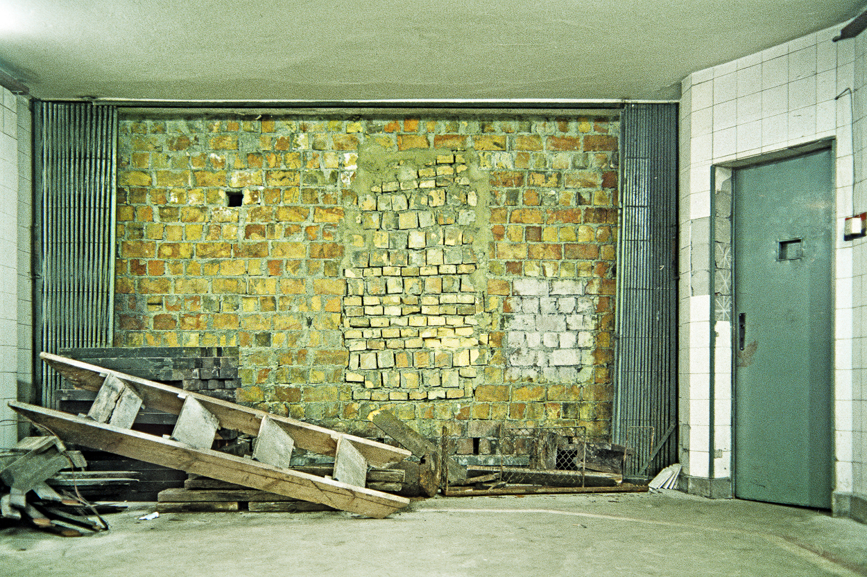A room with a brick wall and a door.