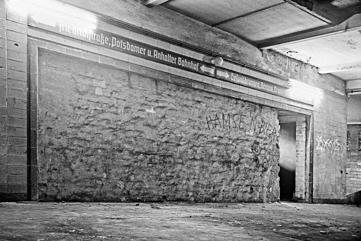 A black and white photo of an abandoned building with graffiti on the walls.