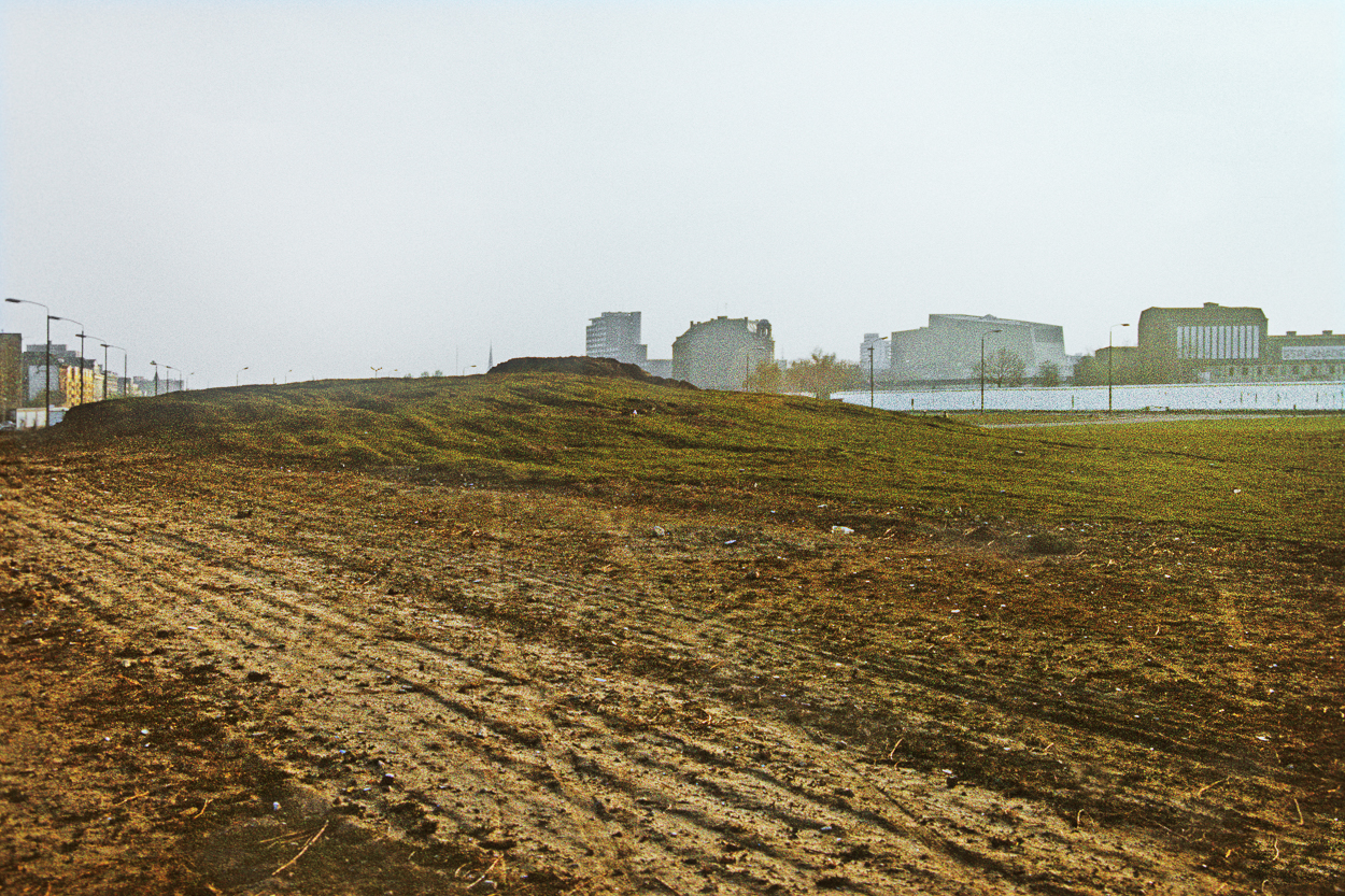 A field with buildings in the background. 