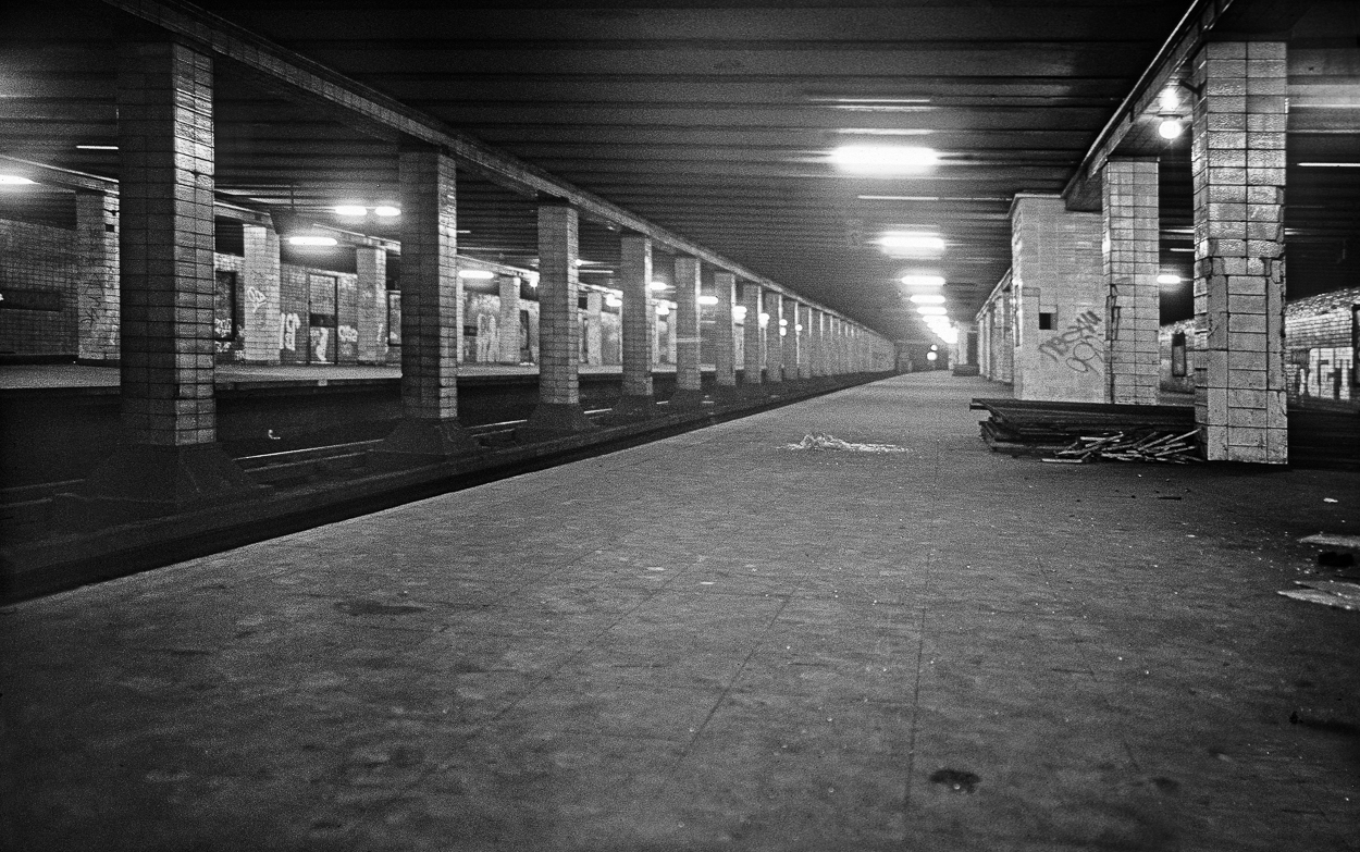 A black and white photo of a subway station.