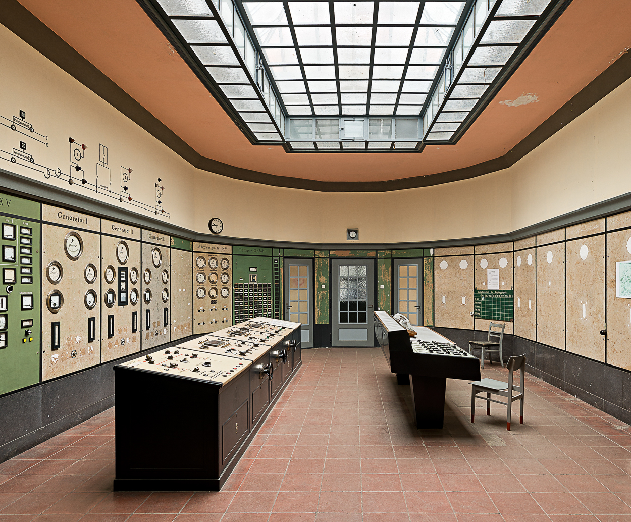 A room with a skylight above a control room filled with lots of electronic equipment.