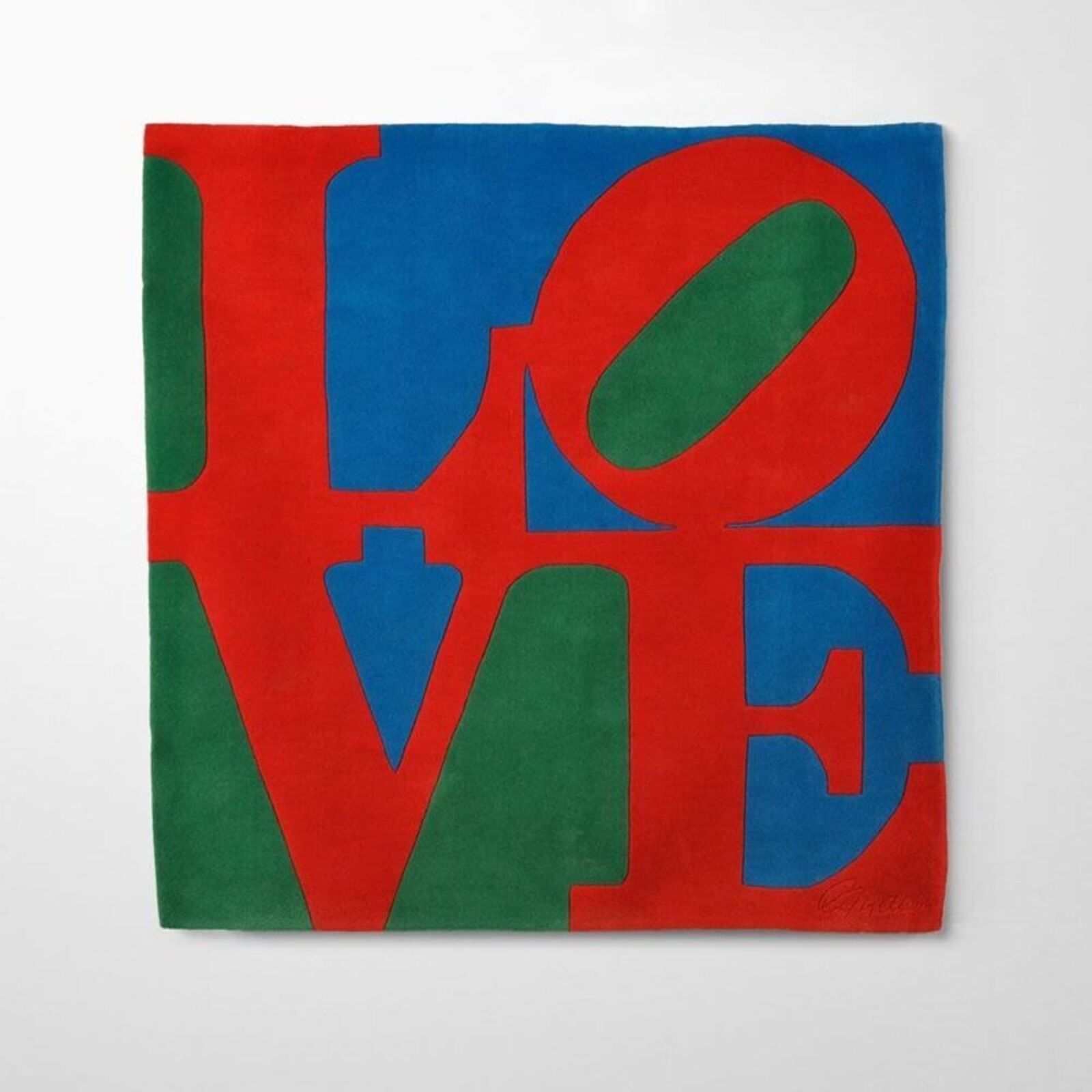 A bold graphic textile featuring large, overlapping letters in primary colors.
