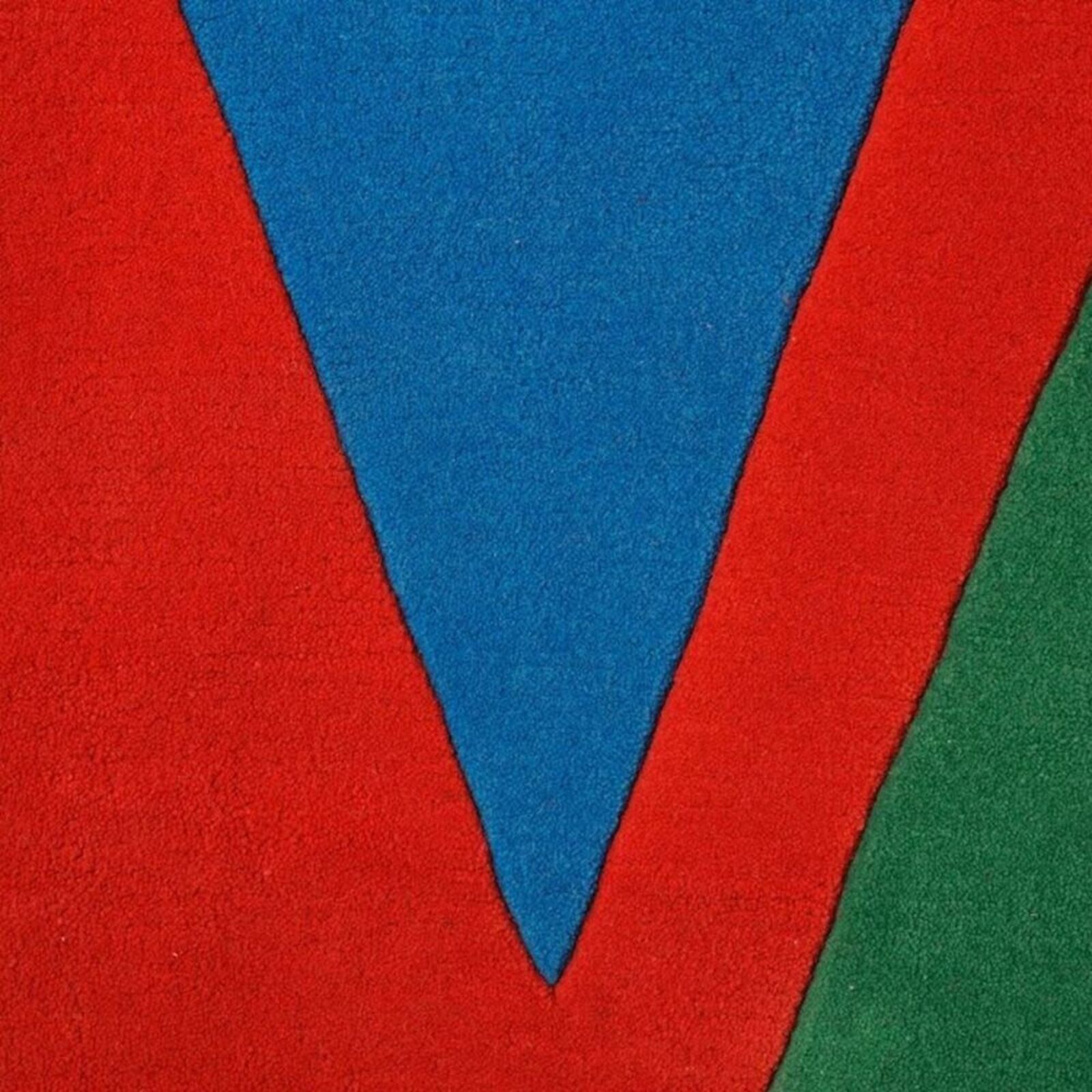 A bold graphic textile featuring large, overlapping letters in primary colors.