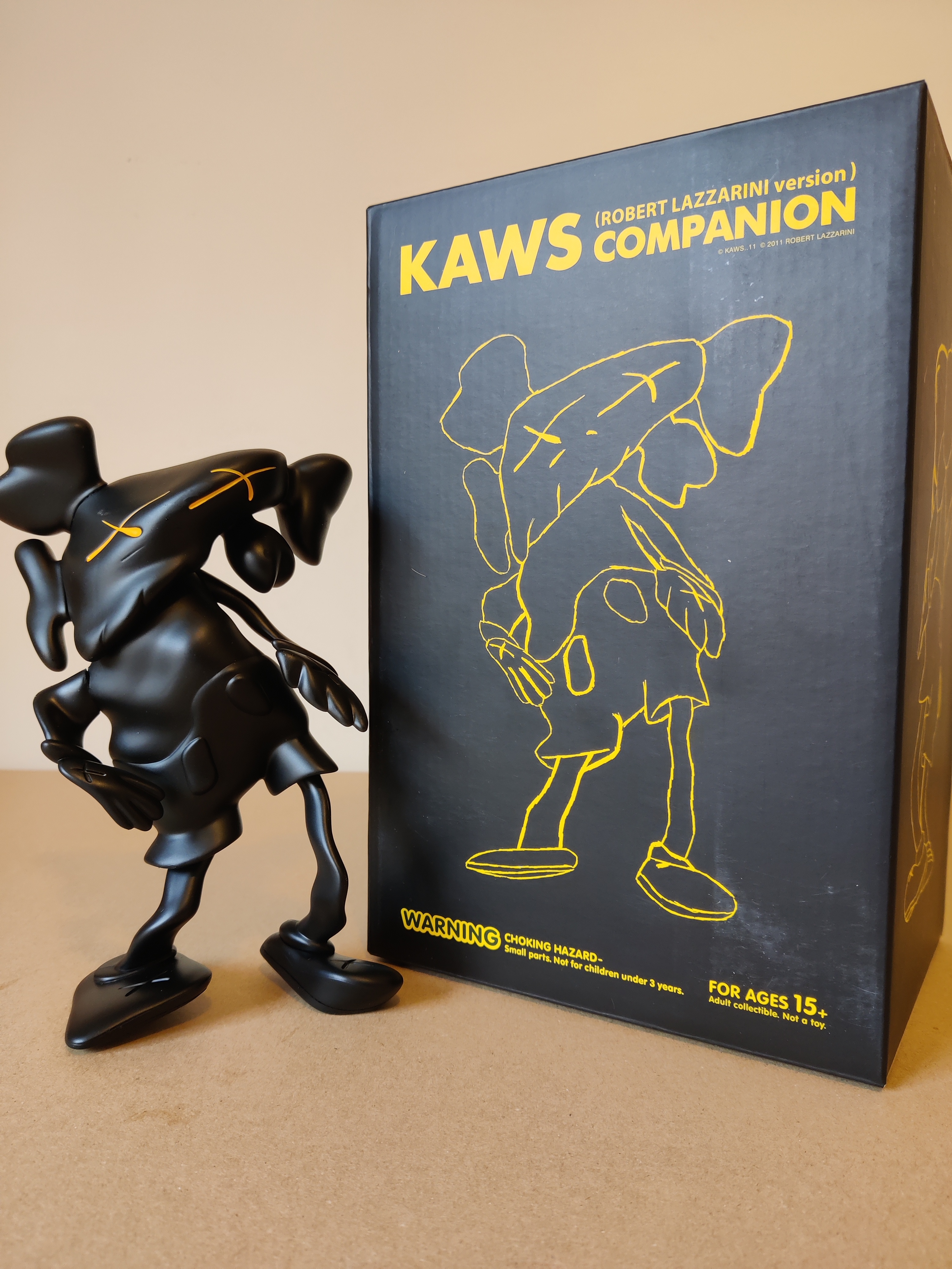 A black figurine of a man with a hat on his head.