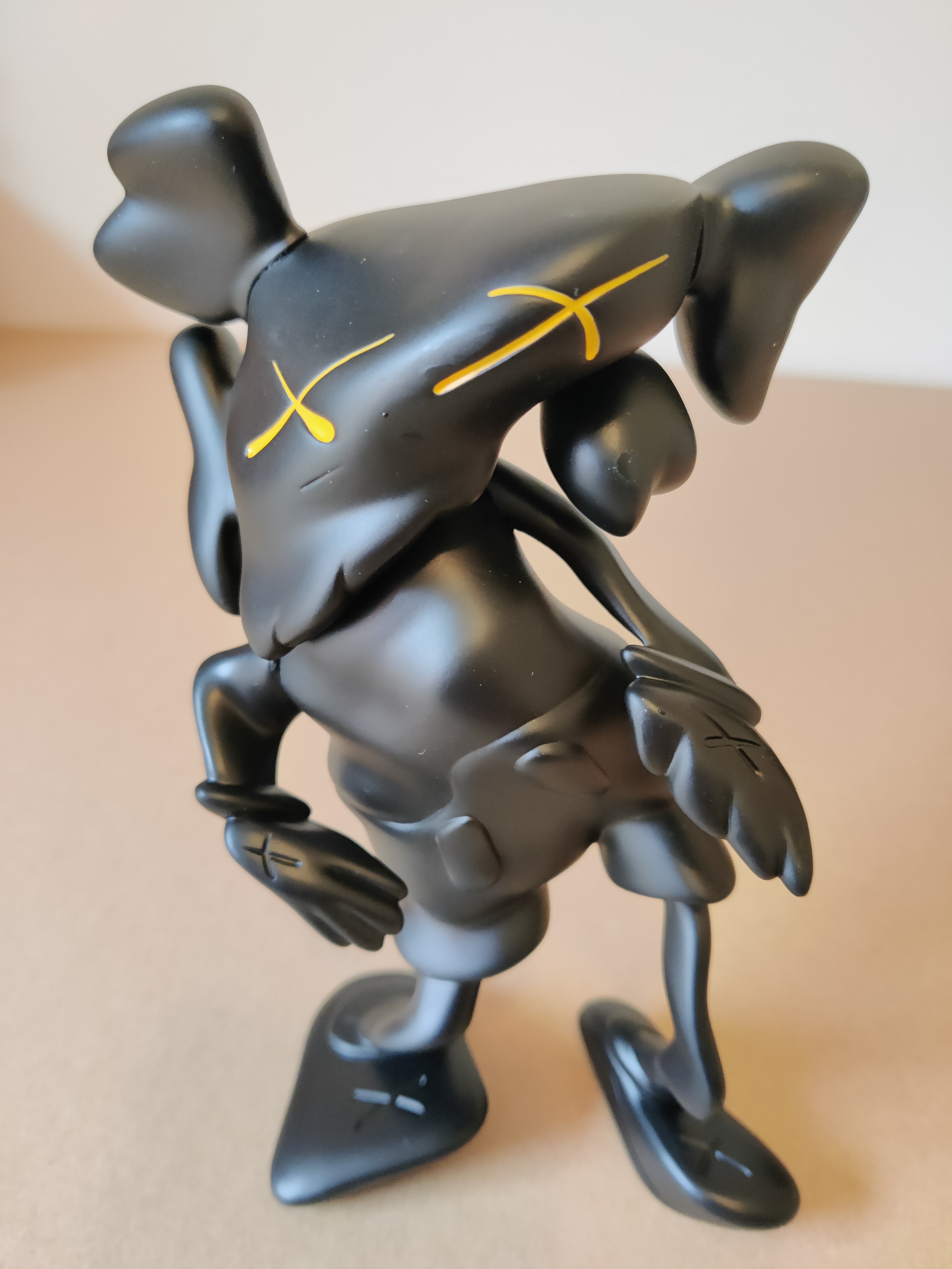 A black figurine of a man with a hat on his head.