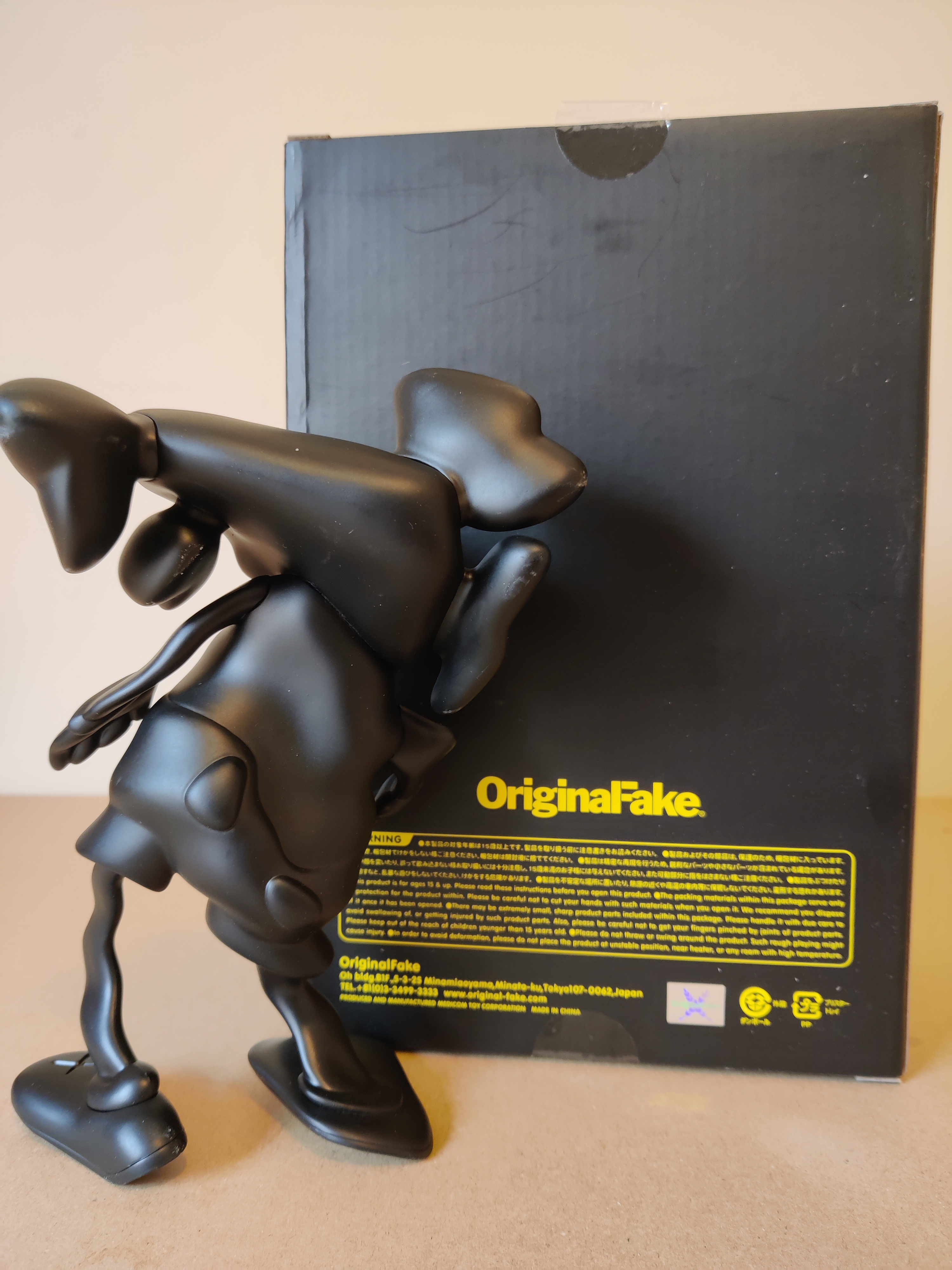 A black figurine of a man with a hat on his head.