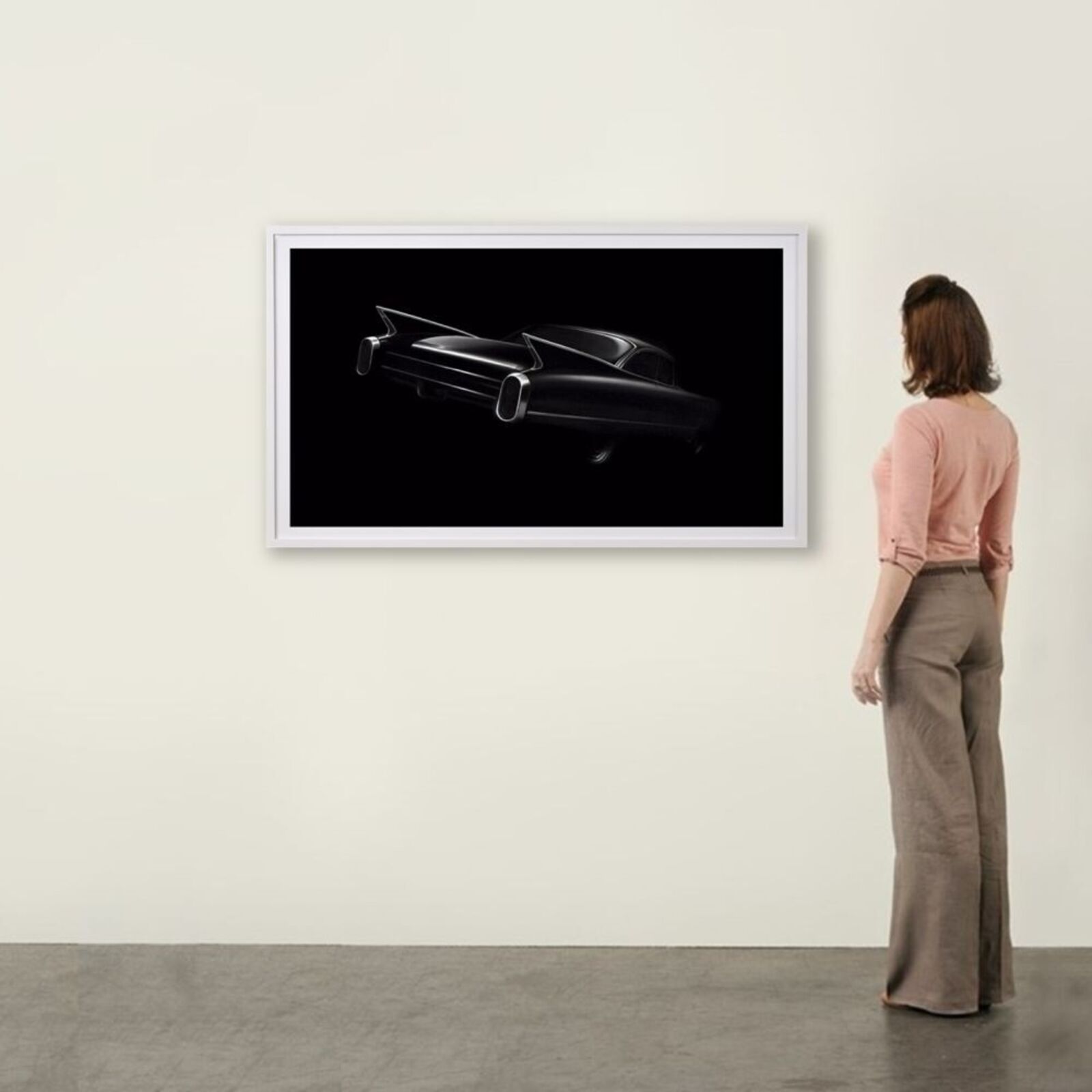 A black and white photo of a classic car on a wall.
