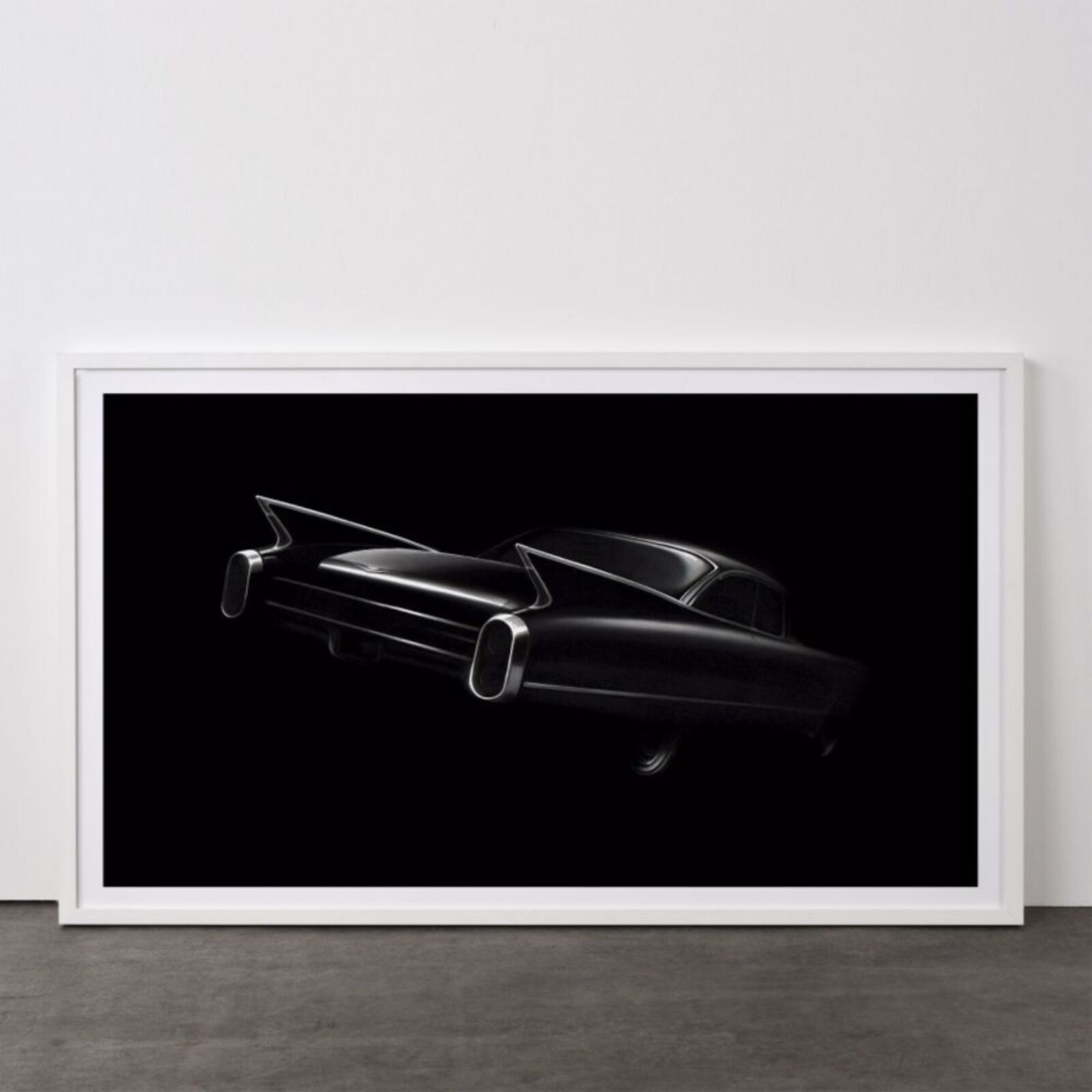 A black and white photo of a classic car on a wall.