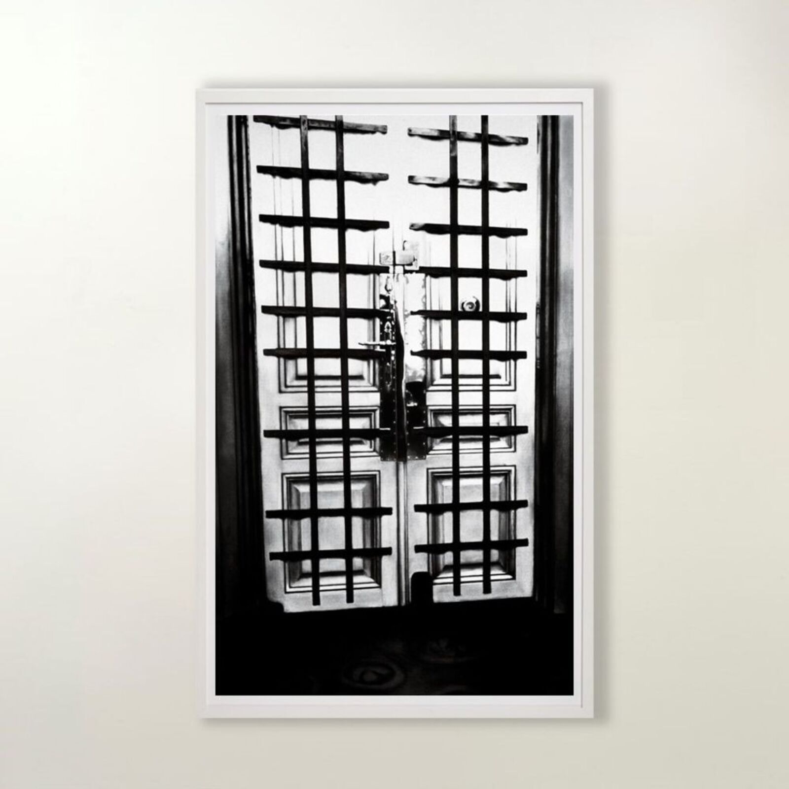 A black and white photo of a door with bars on it.