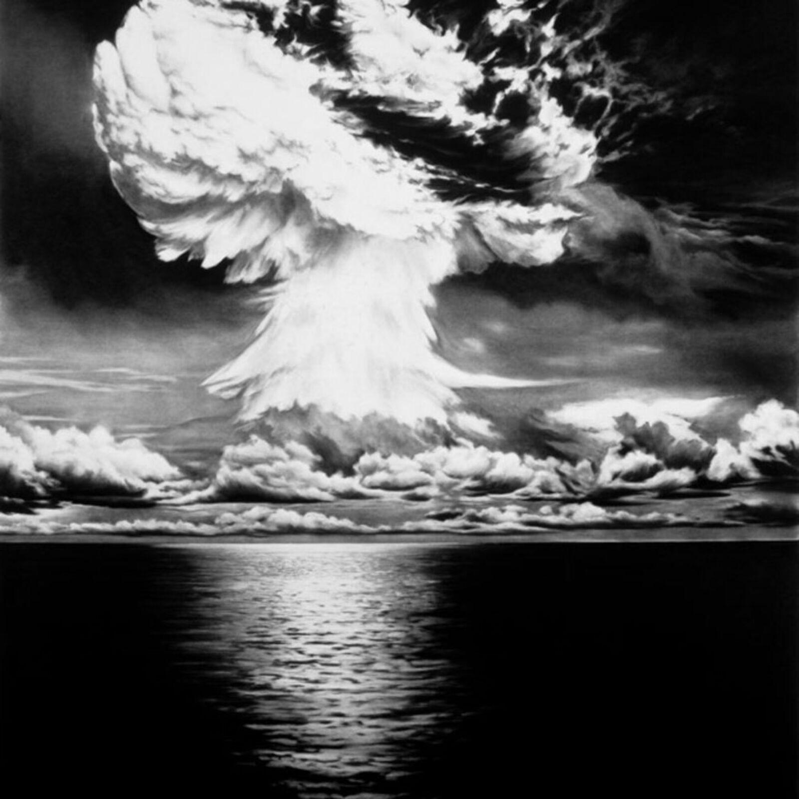 A black and white photo of a mushroom cloud over the ocean.