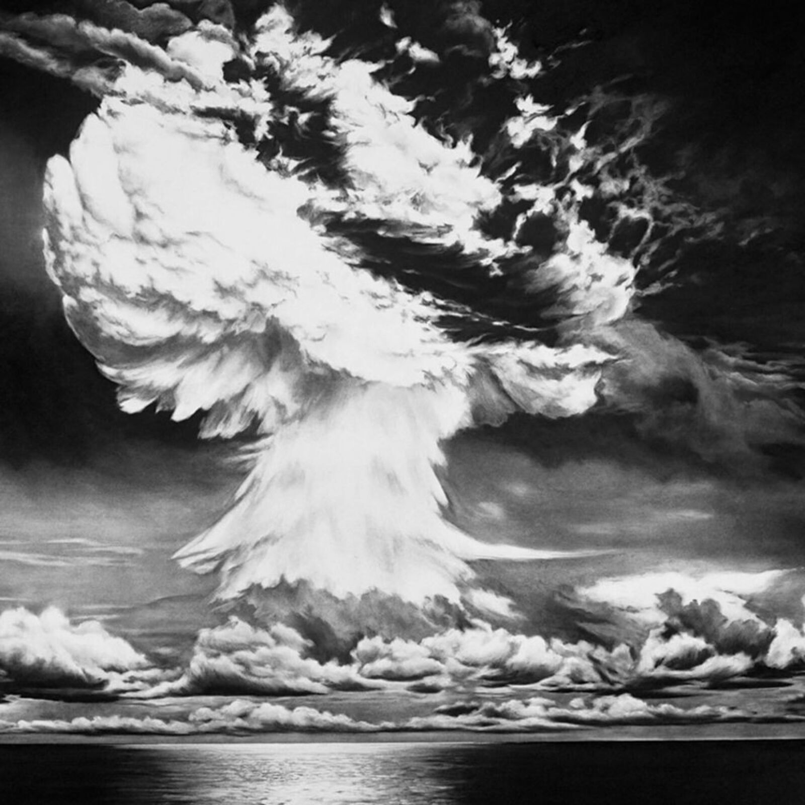 A black and white photo of a mushroom cloud over the ocean.