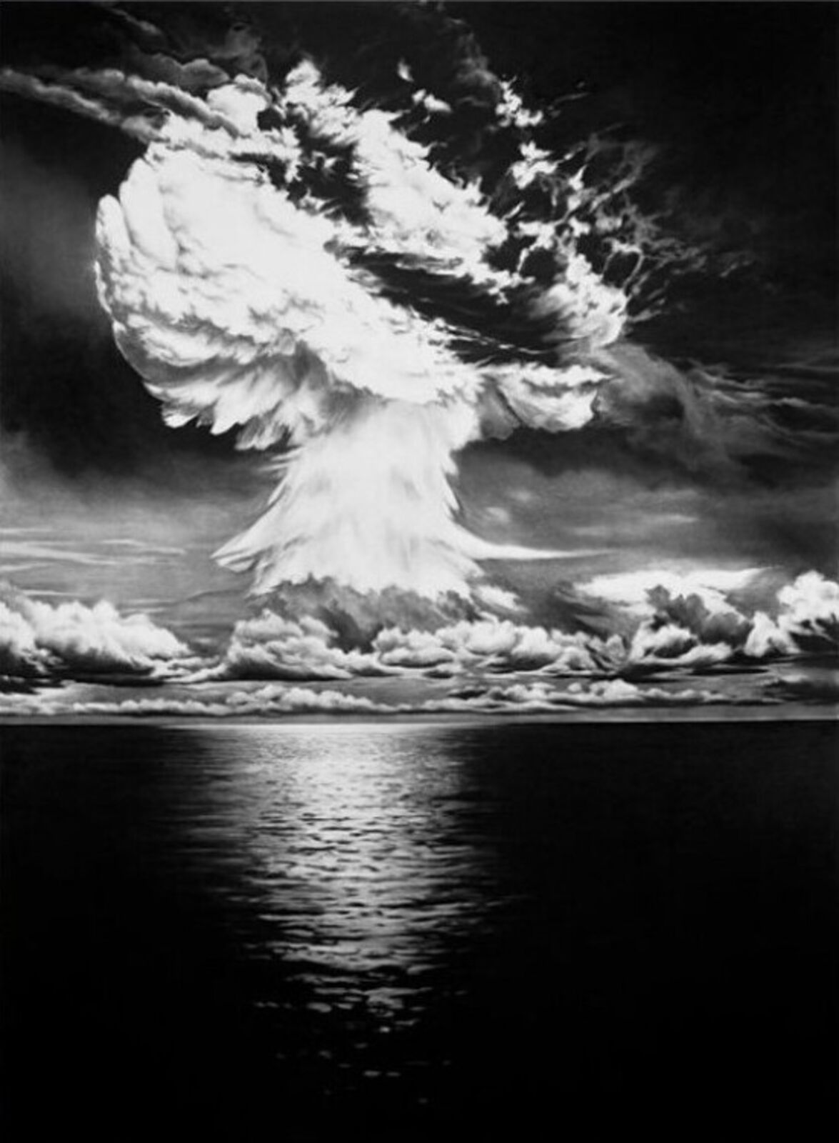 A black and white photo of a mushroom cloud over the ocean.