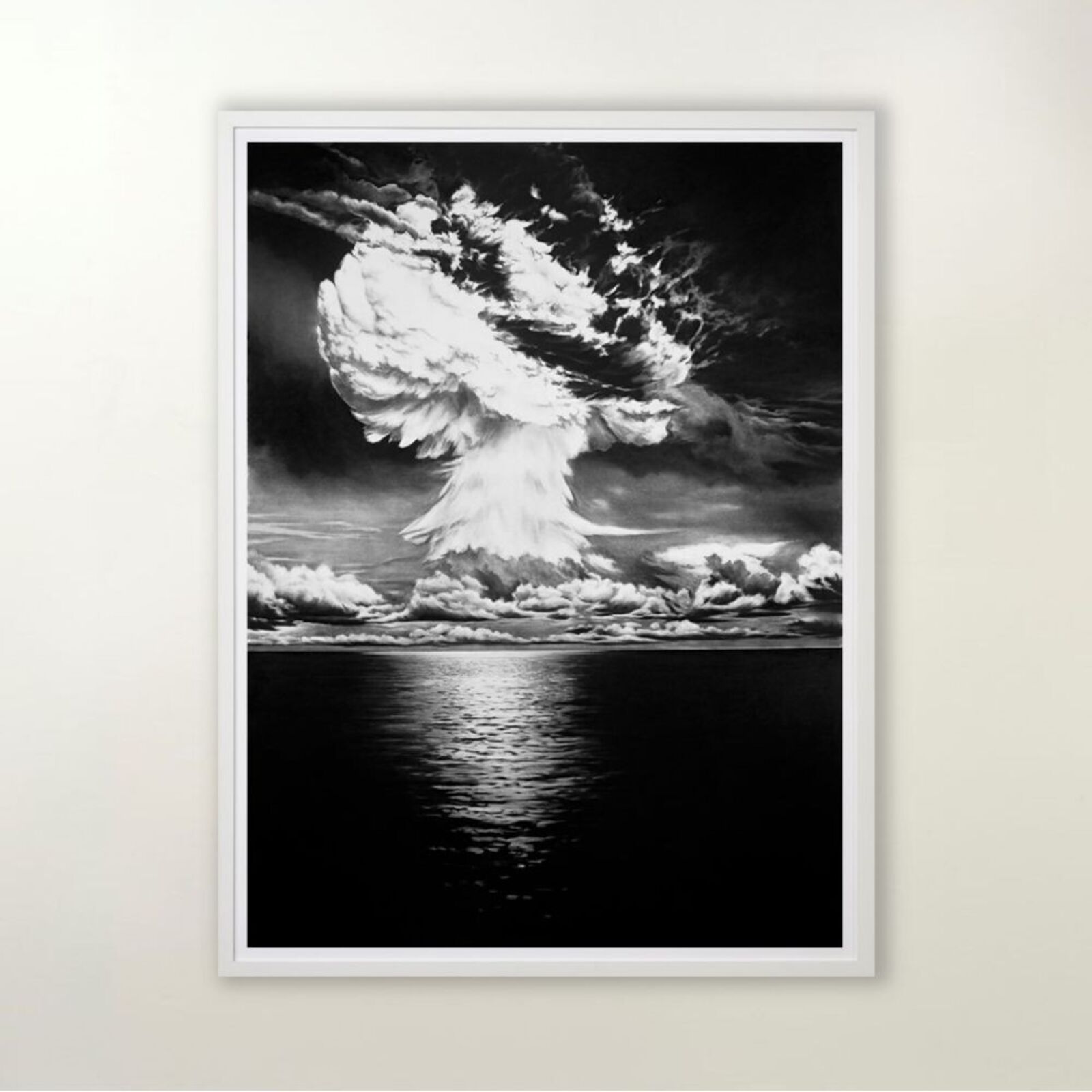A black and white photo of a mushroom cloud over the ocean.