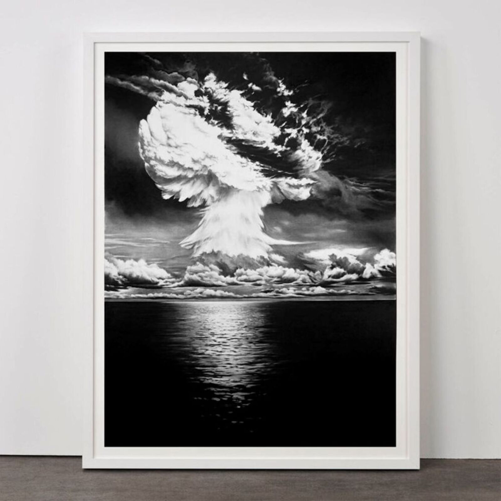 A black and white photo of a mushroom cloud over the ocean.