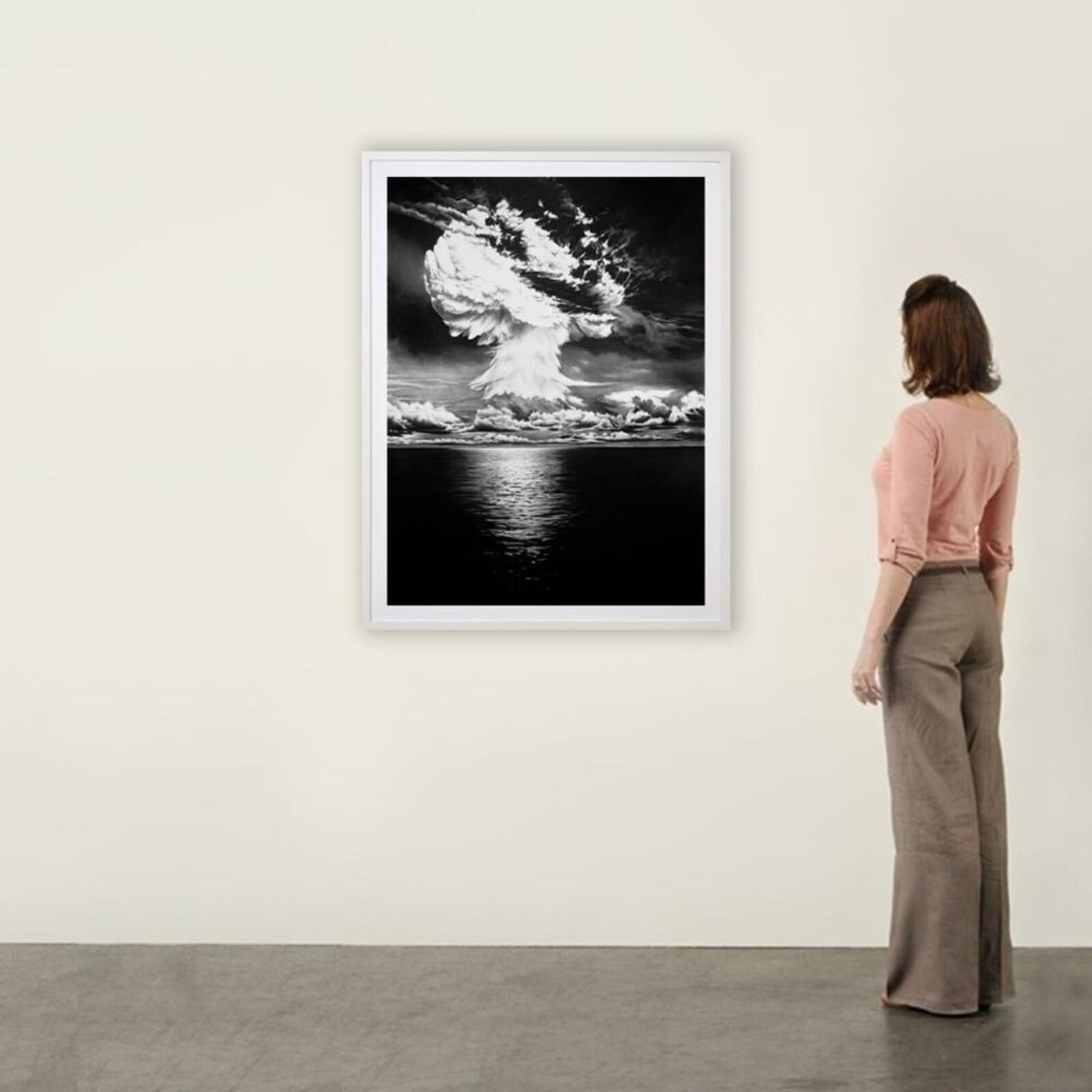 A black and white photo of a mushroom cloud over the ocean.