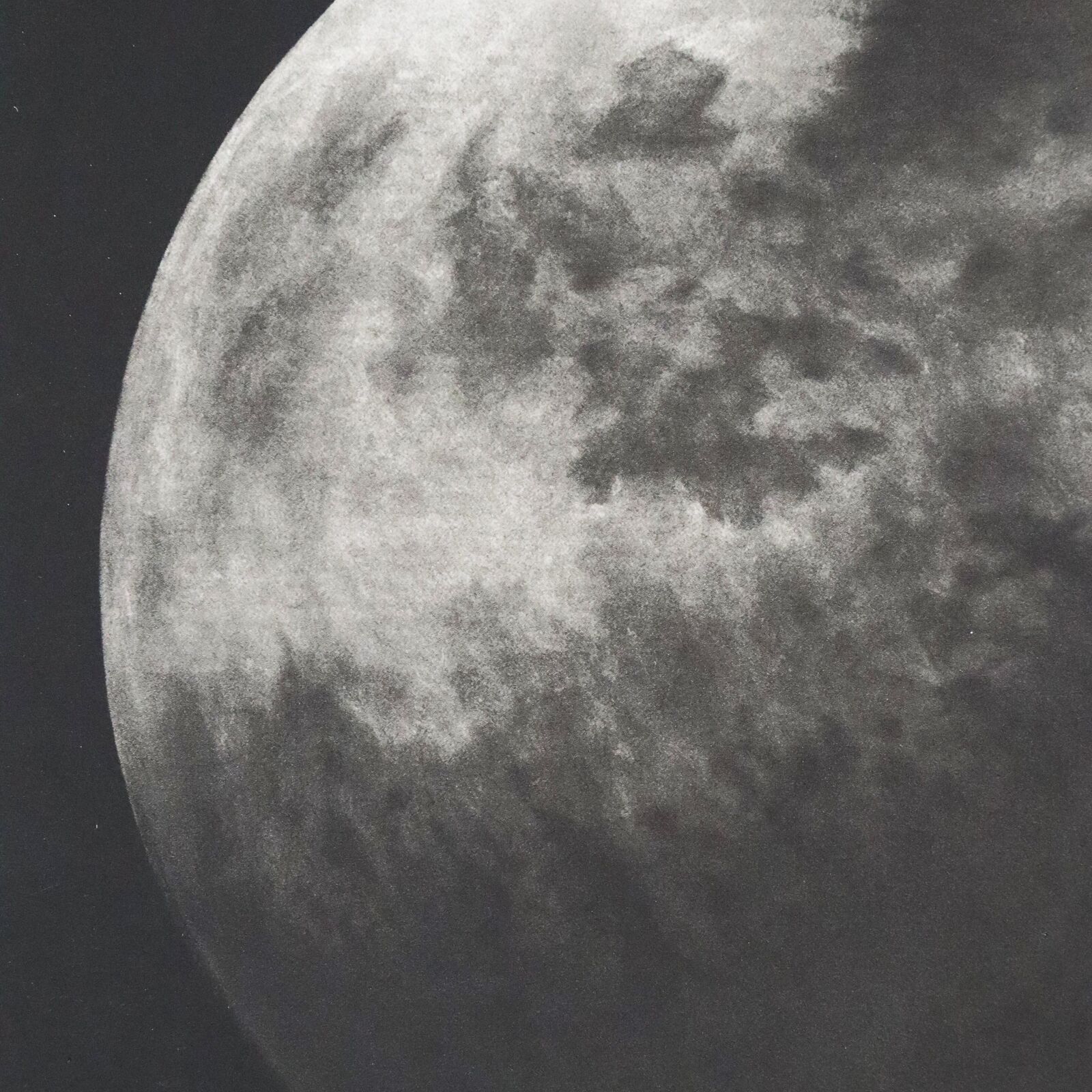 A black and white photo of a full moon in the sky.