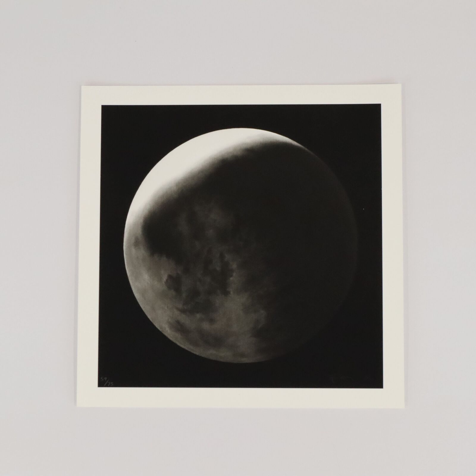 A black and white photo of a full moon in the sky.