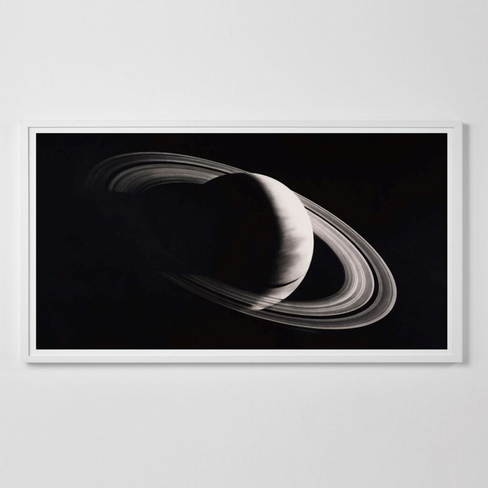 A black and white photo of a saturn in a white frame.